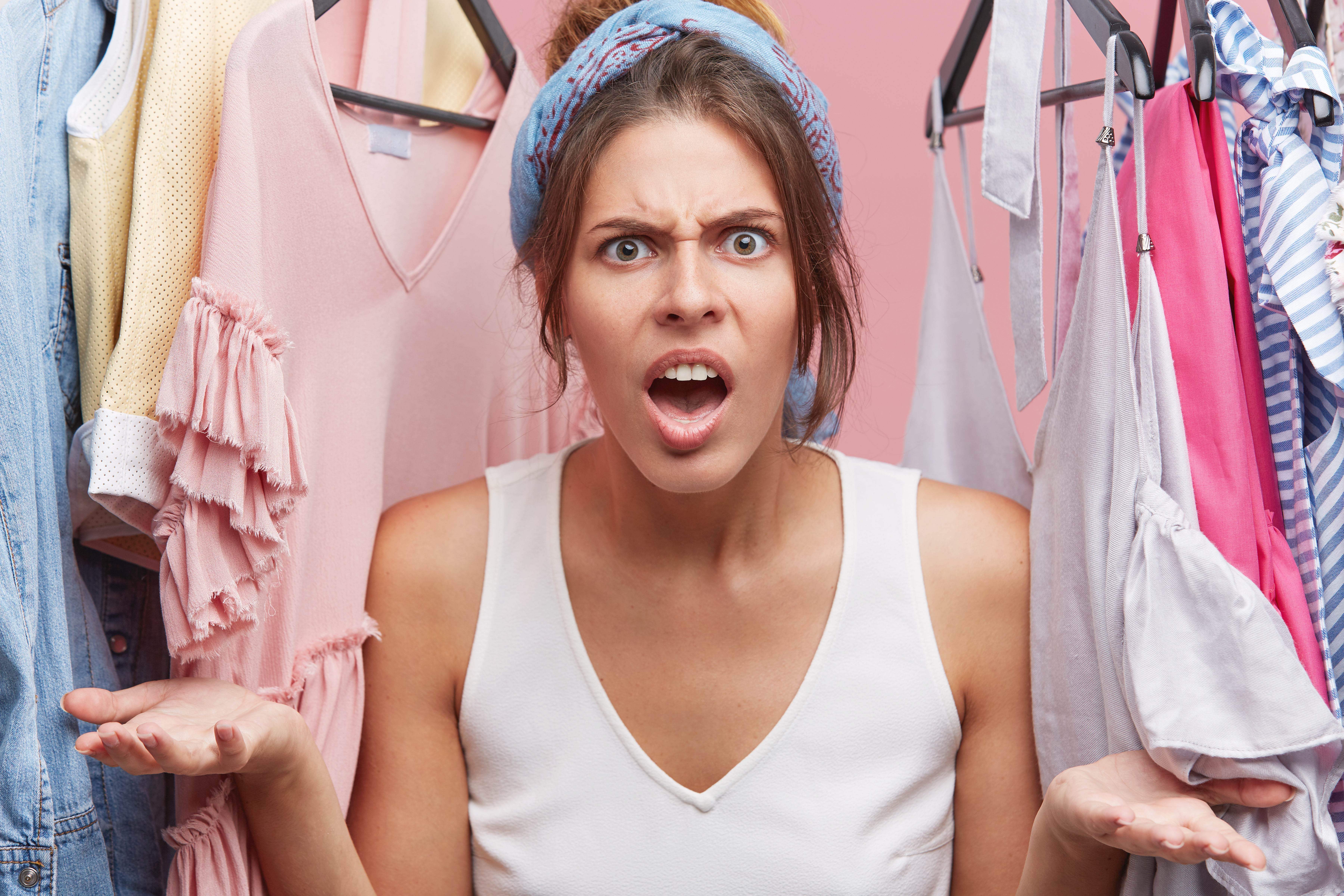 Woman furious as she stands in the midst of clothing | Source: wayhomestudio on Freepik