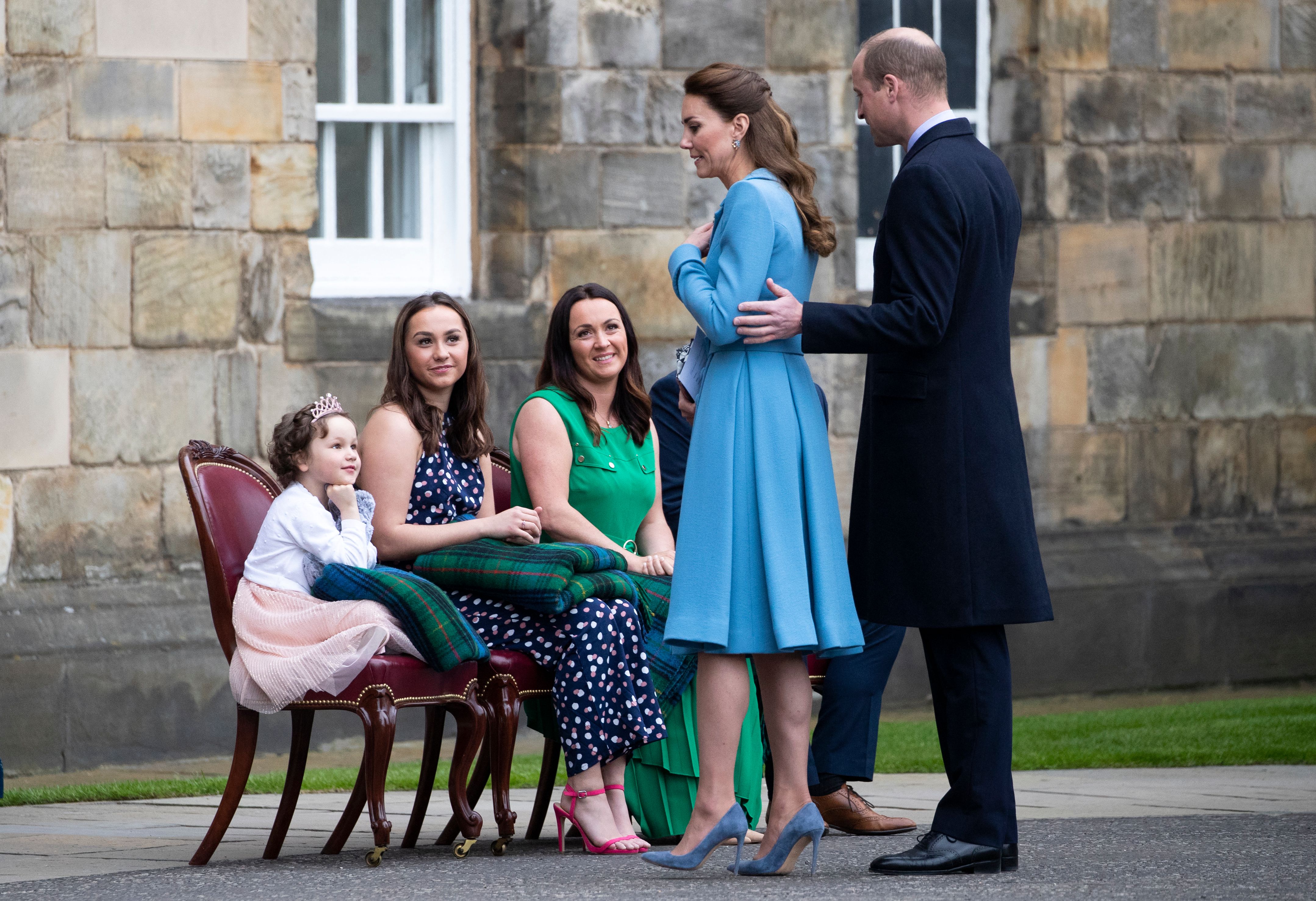 Five year-old cancer patient Mila Sneddon (L), who features in an image from the Hold Still photography project, speaks to Prince William and Princess Kate as special guests of the Royal couple, at the Palace of Holyroodhouse in Edinburgh, Scotland on May 27, 2021 | Source: Getty Images