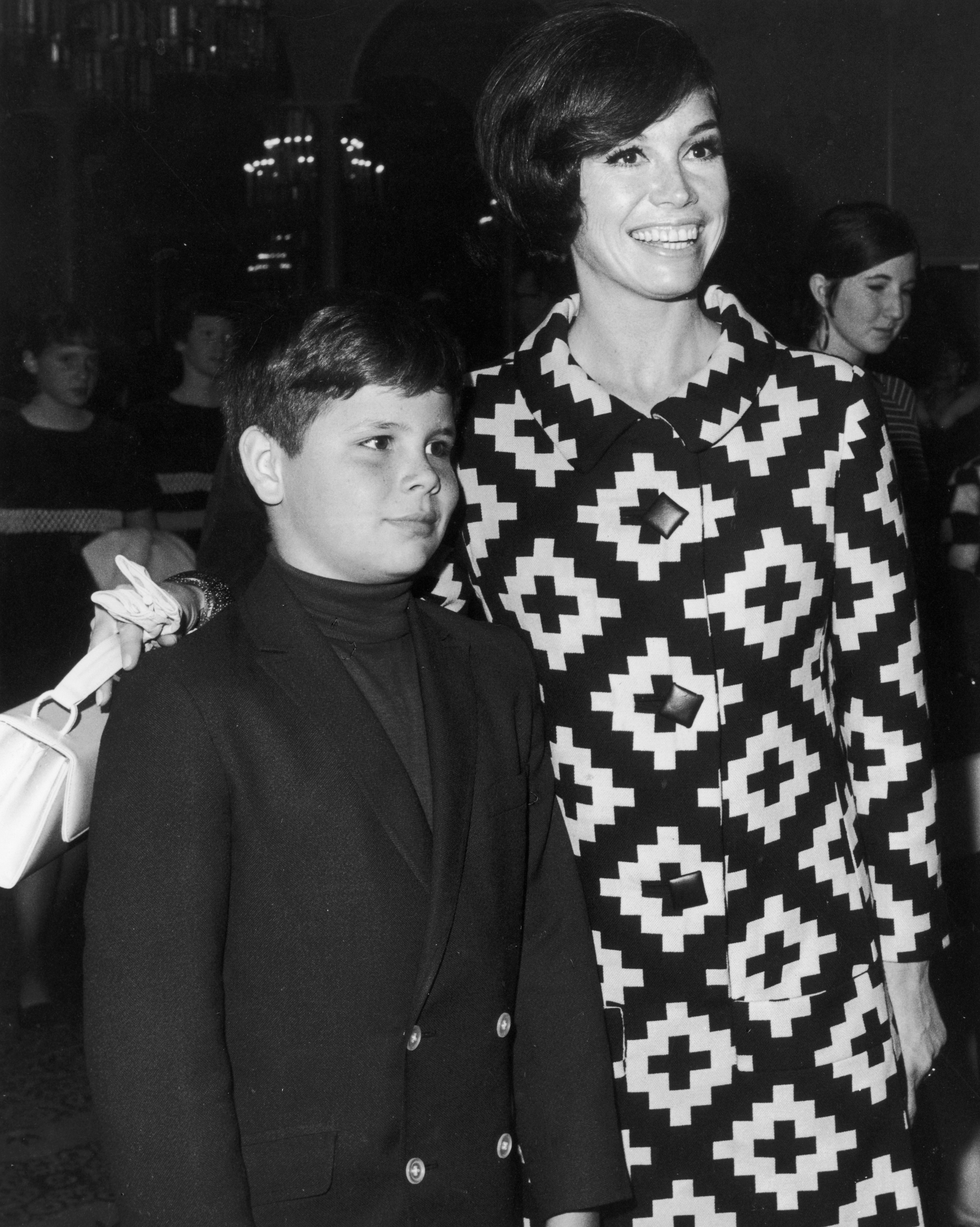 Mary Tyler Moore puts her arm around her son, Richard "Richie" Meeker Jr., at a Teach Foundation benefit in 1968. | Source: Getty Images