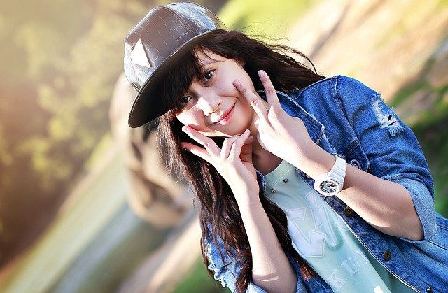 Teenager girl with black cap makes peace sign near her face | Photo: Pixabay
