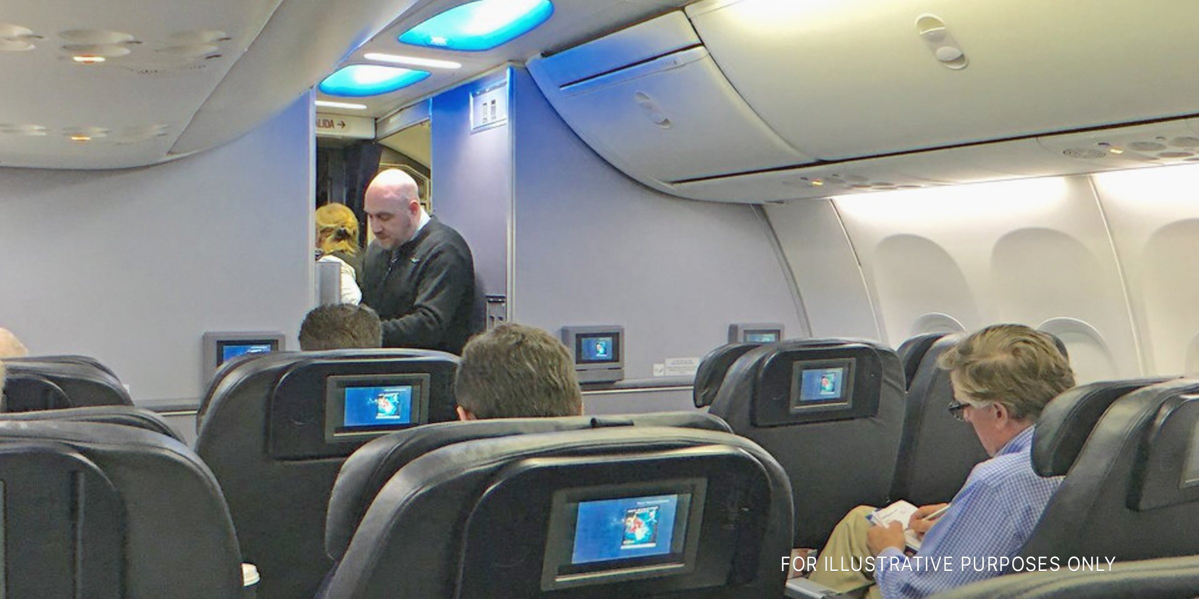 Flight attendant on plane | Source: Flickr.com/alan-light (CC BY 2.0)