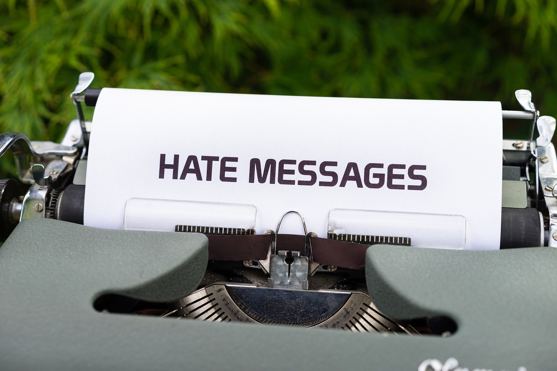 Pictured: A typewriter showing a document that reads: "Hate messages" referencing online cyberbullying | Source: Pixabay