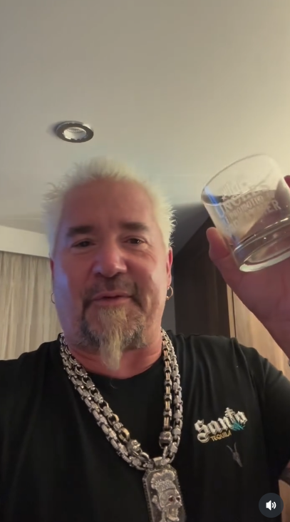 Guy Fieri holds up a personalized glass he received from a family friend's daughter, from a video posted in June 2024 | Source: Instagram/guyfieri
