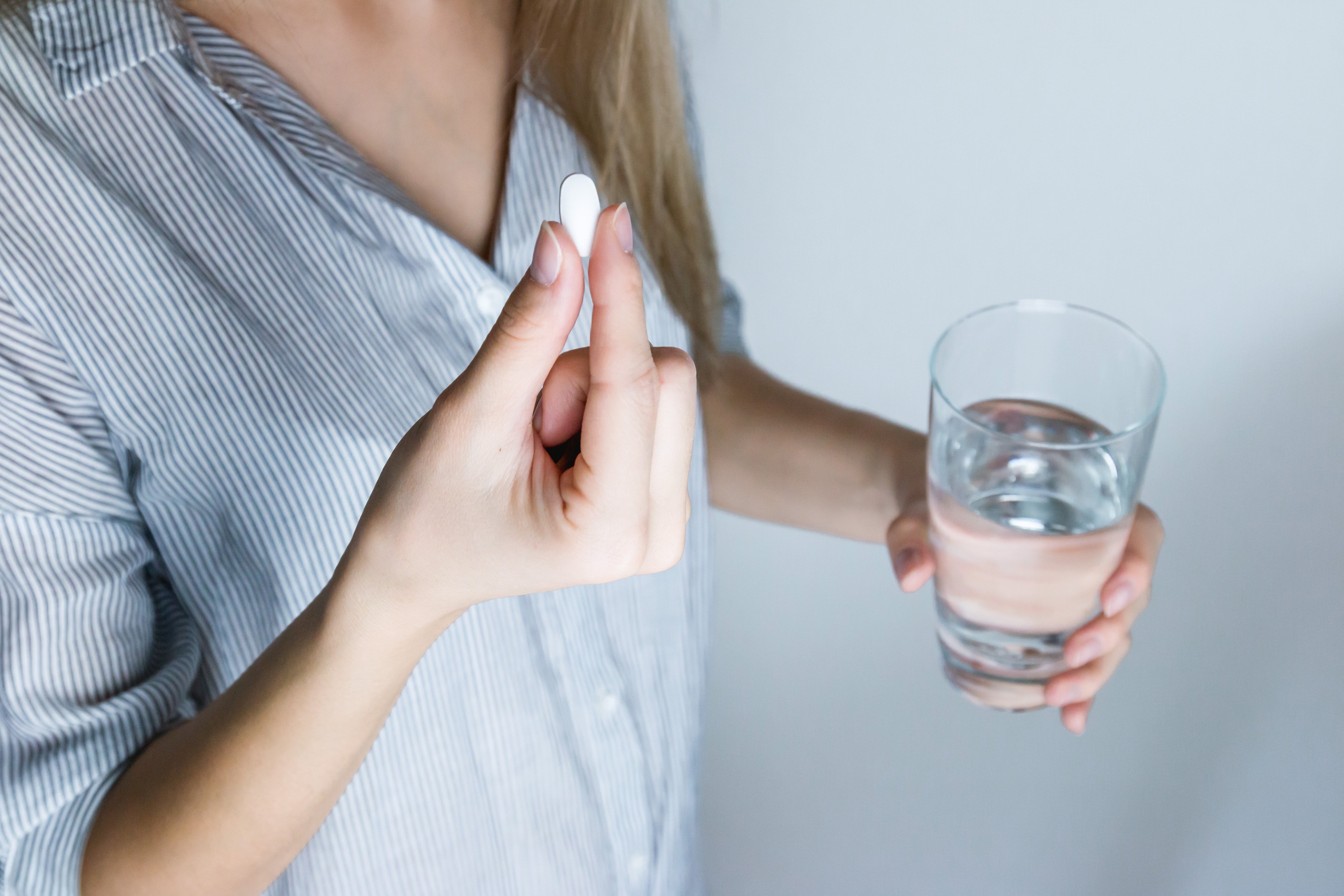 A woman takes a birth control pill. l Image: Pexels.