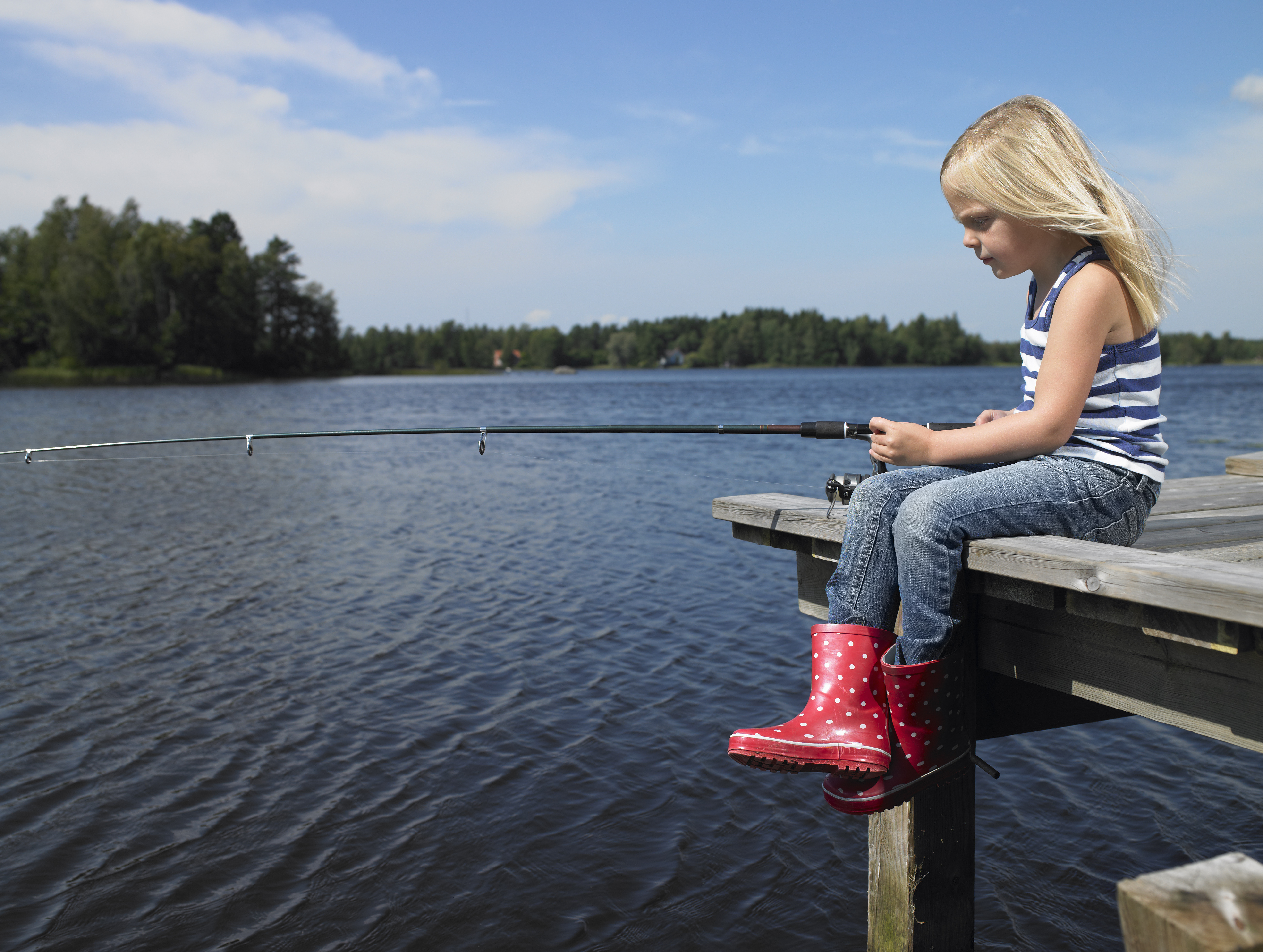 Girl fishing from a dock | Source: Getty Images
