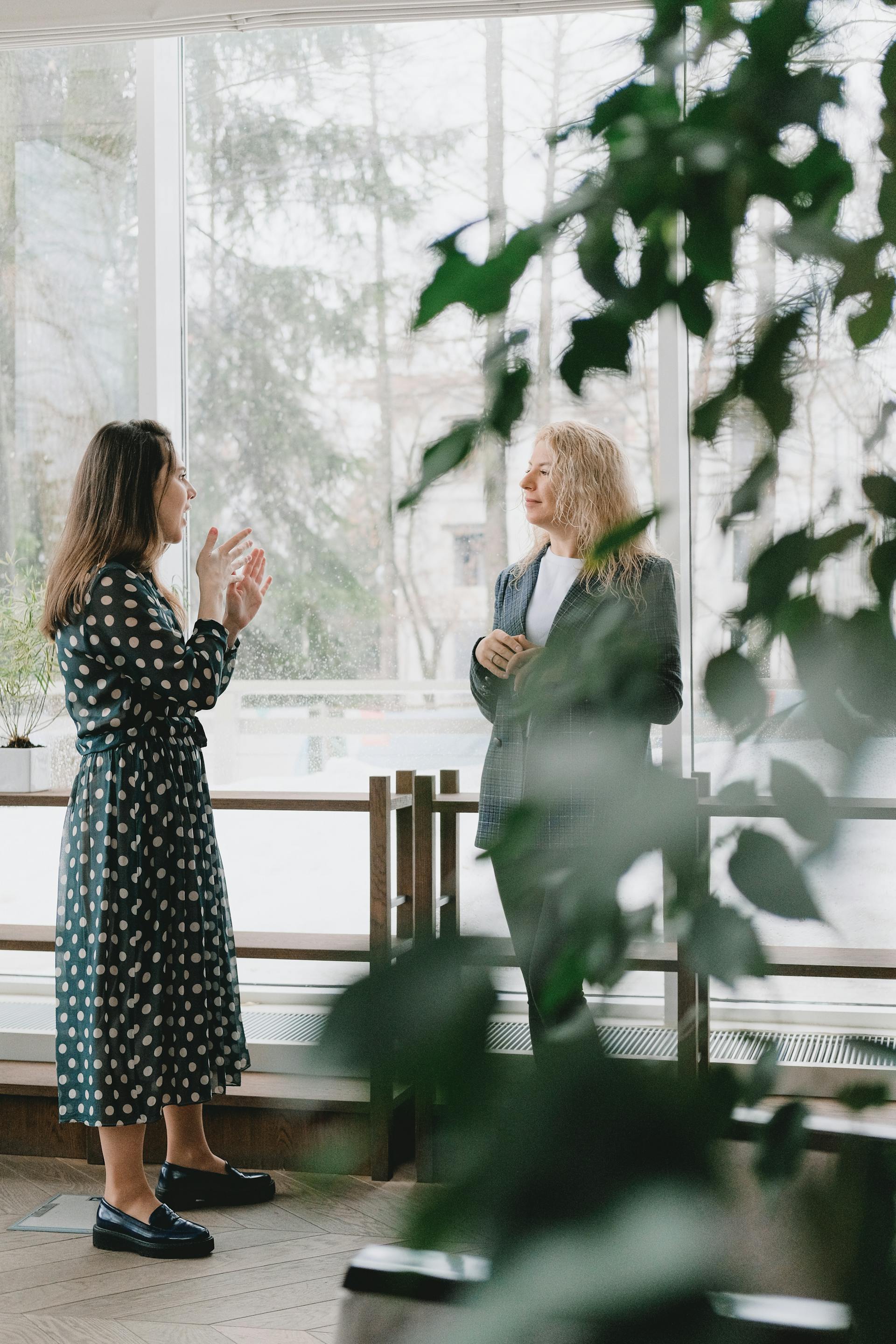 Two female coworkers chatting in the office | Source: Pexels