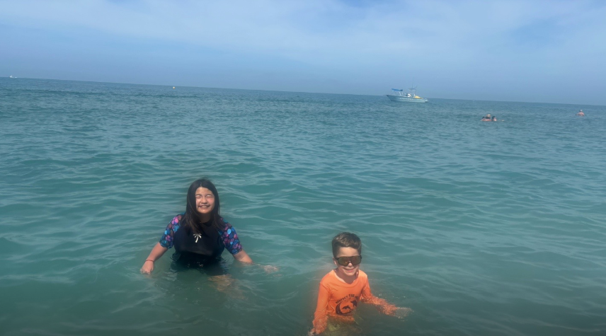 Two of Amanda "Mandy" Karolkiewicz and Kristopher Karolkiewicz's children stand in the ocean during the family's spring break vacation. | Source: TikTok/mandykarolk