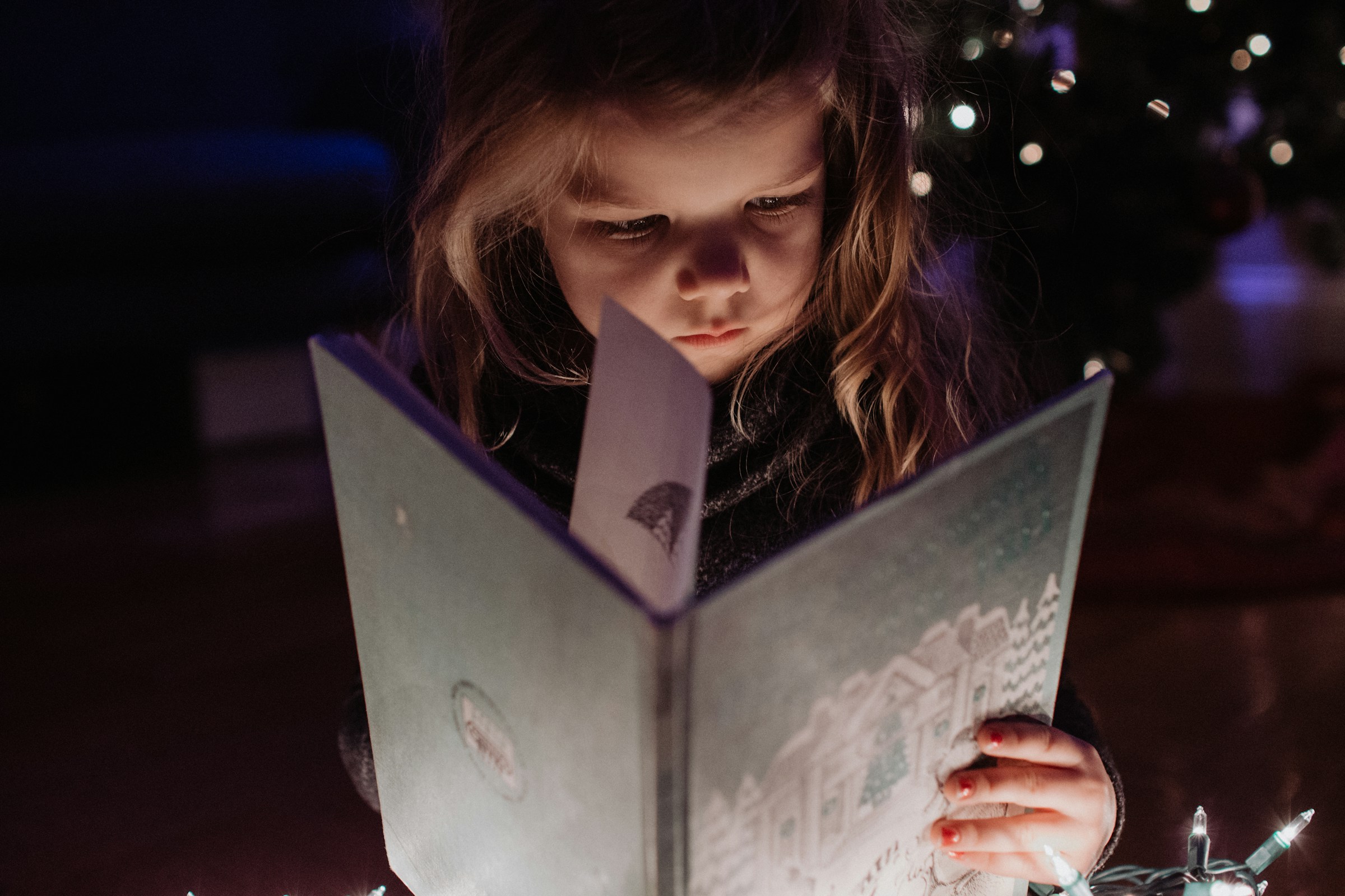 A little girl holding a book | Source: Unsplash