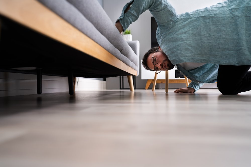 A photo of a man searching under a chair | Photo: Shutterstock