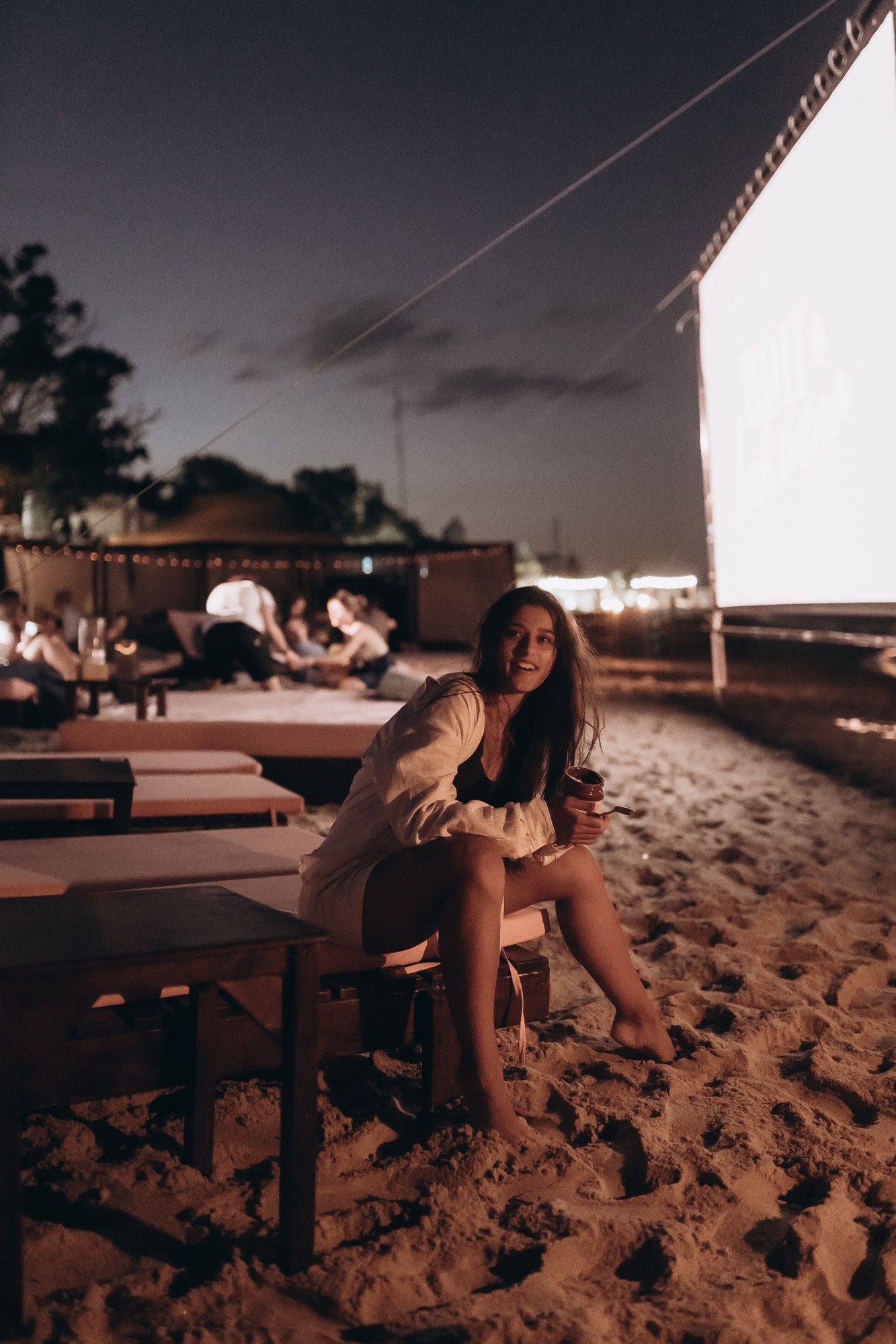 A woman sitting with a screen and people in the background | Source: Freepik