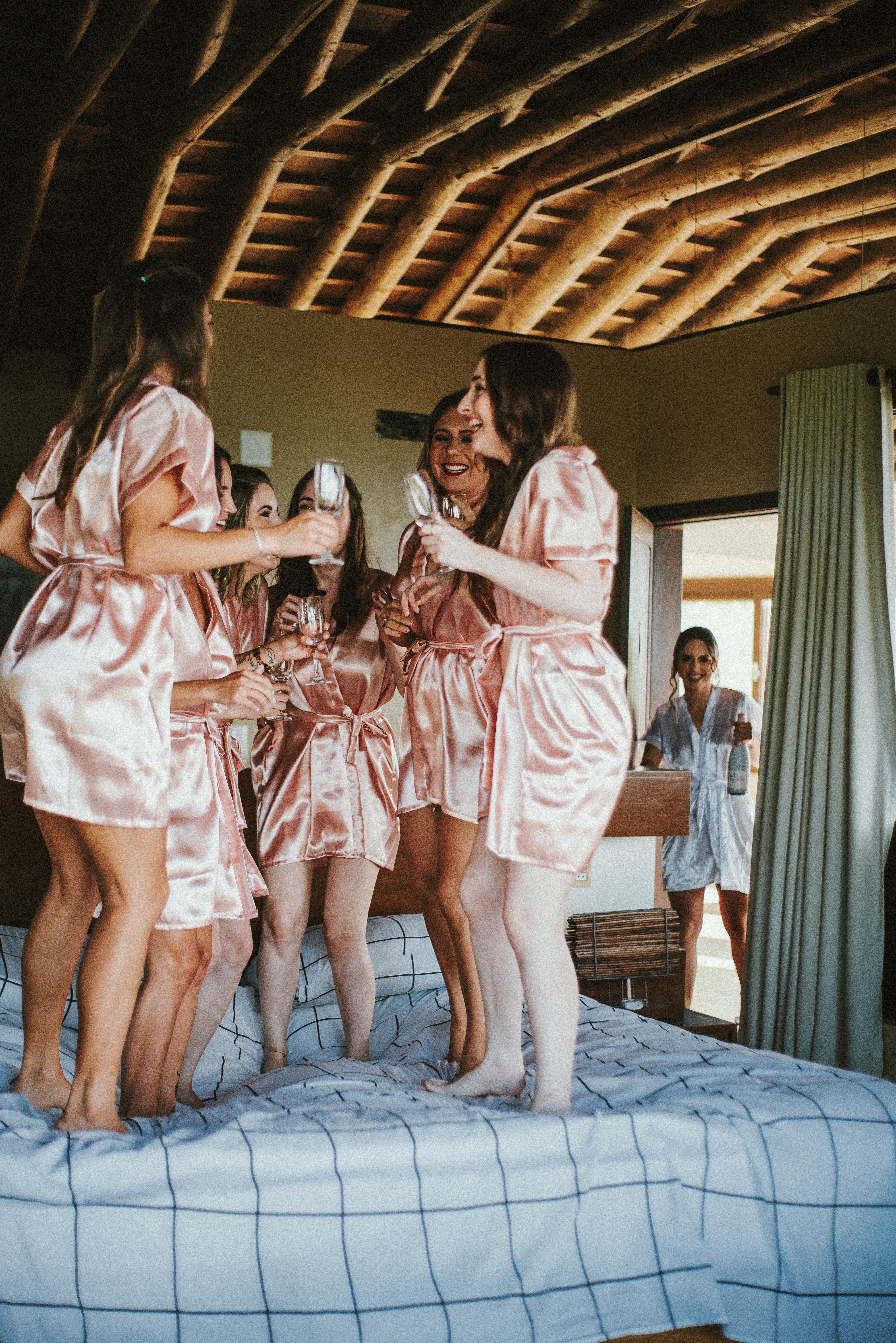 For illustration purposes only. Bridesmaids have fun jumping on a bed | Source: Pexels