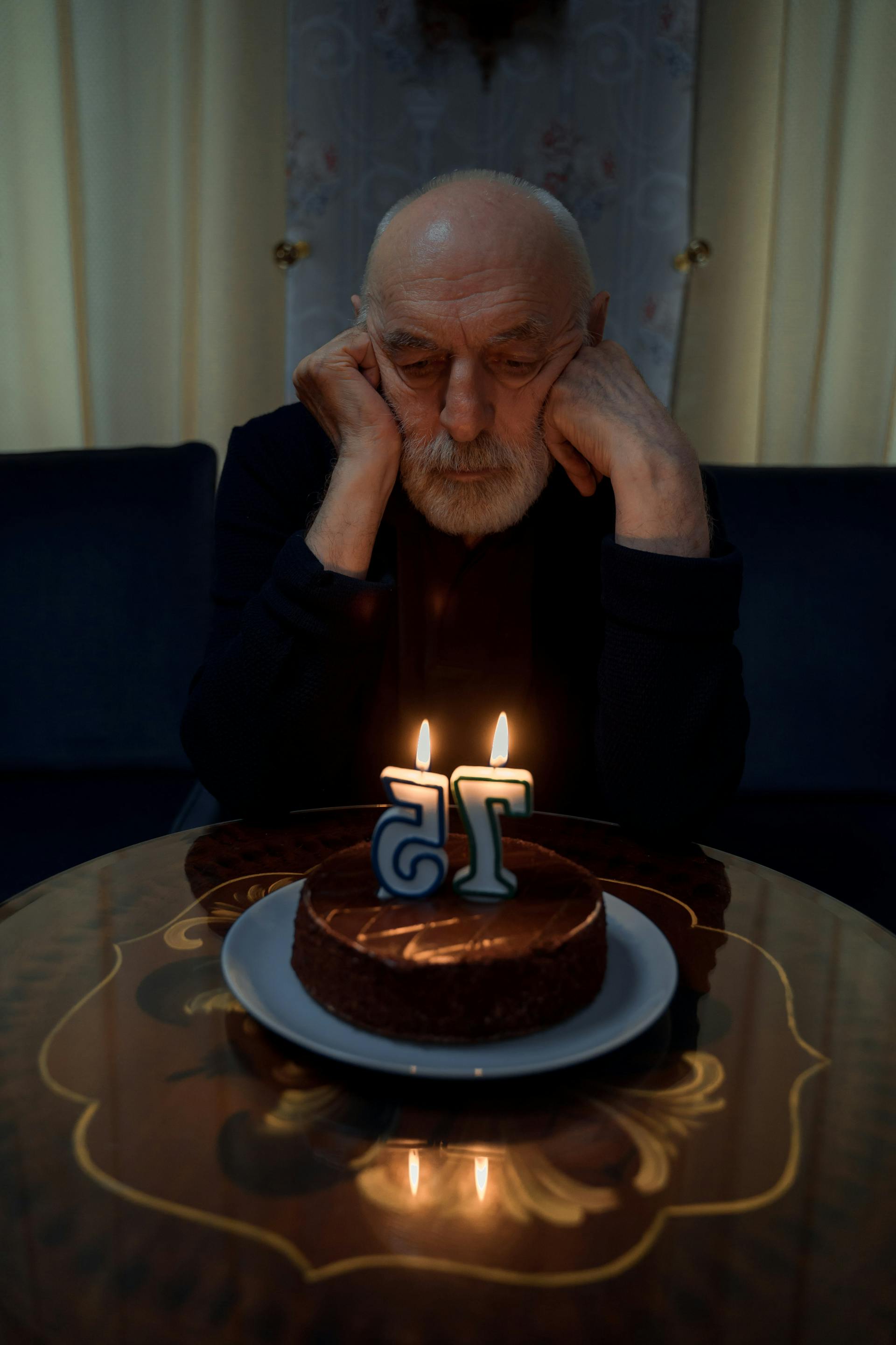 A sad old man looking at his birthday cake | Source: Pexels