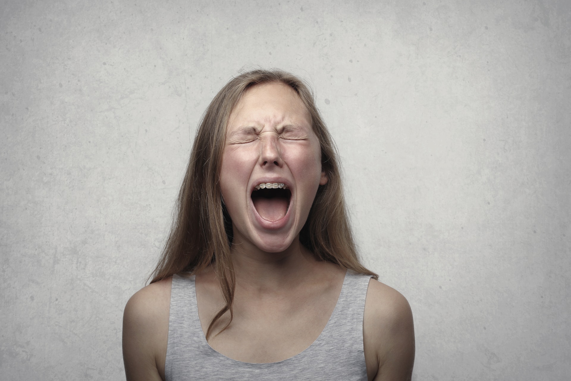 A woman screaming with her eyes closed | Source: Pexels