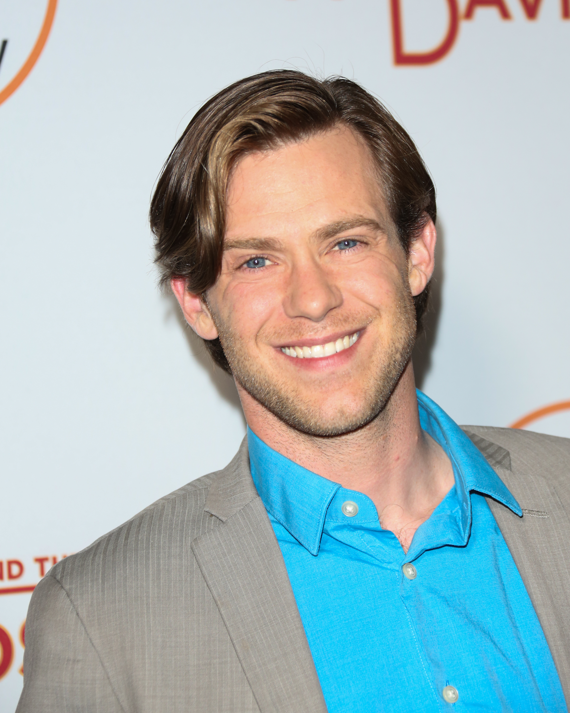 All eyes on Bug Hall as he steps out in a crisp light suit and electric blue shirt, flashing a bright smile while attending Discovery Channel's "Harley And The Davidsons" celebration at the Petersen Automotive Museum in Los Angeles, California, on 1 August 2016 — his polished look a striking contrast to the rugged, rural life he would later embrace.