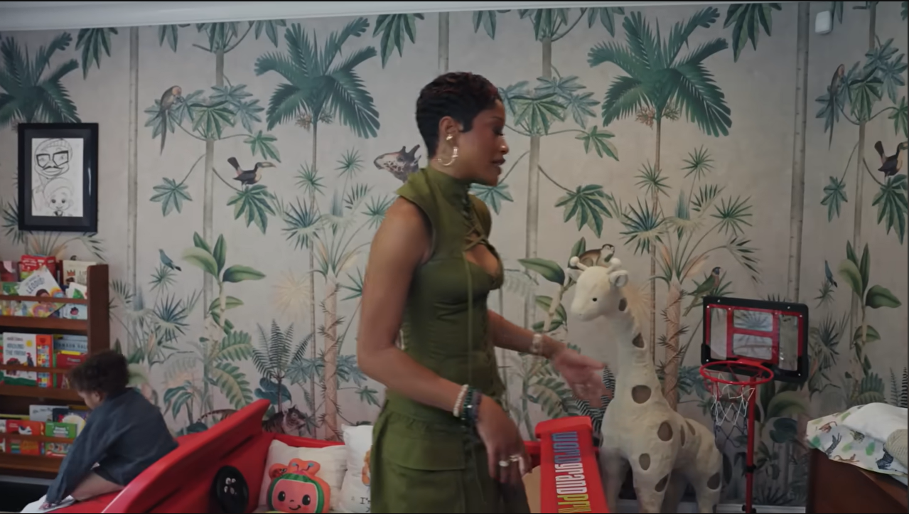 Every kid's dream! Palmer stands next to a giant plush giraffe and a mini basketball hoop inside the playful suite. | Source: YouTube/@Archdigest