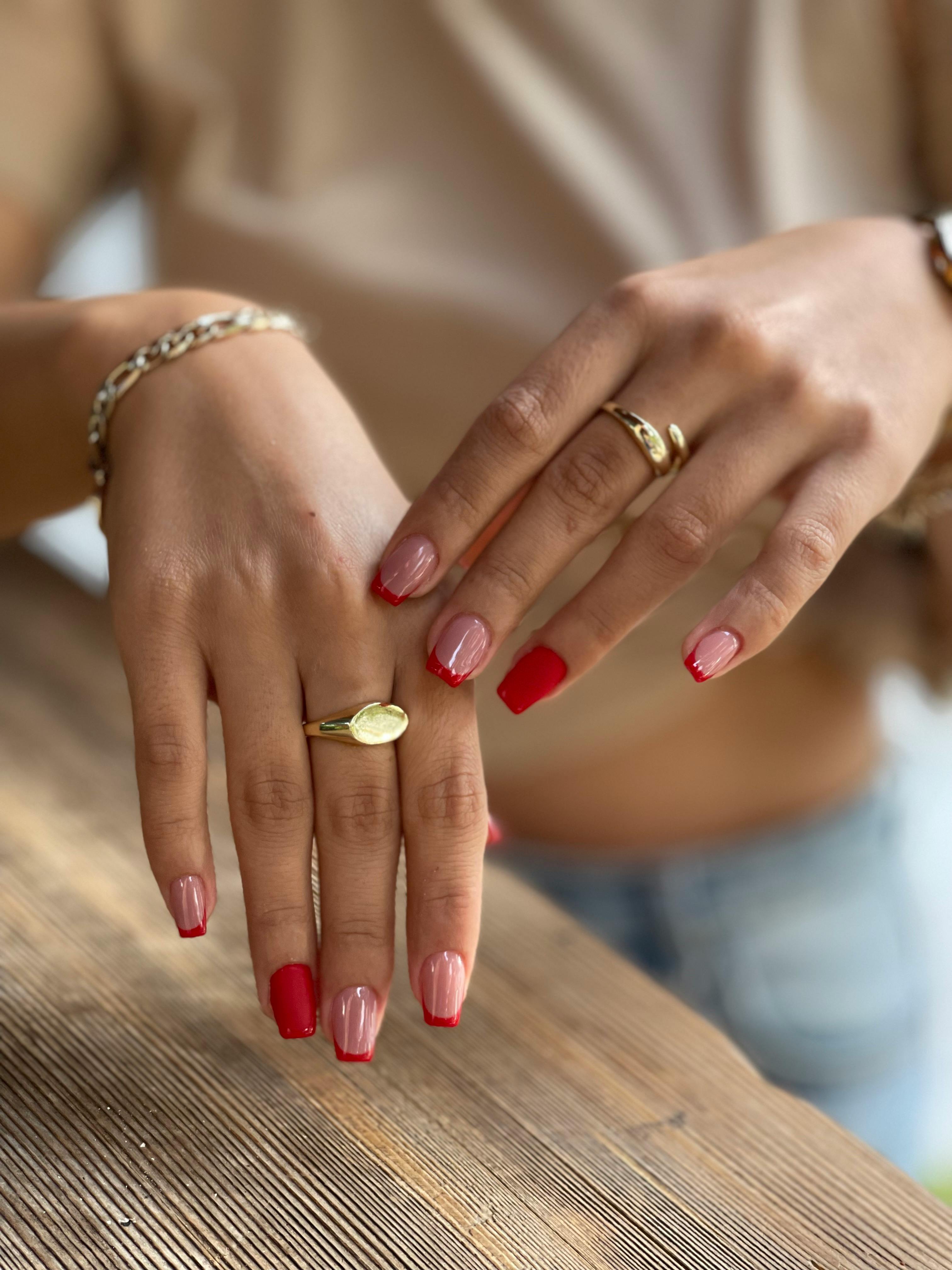 Woman with French and red nail polish | Source: Pexels