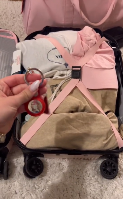 Katarina Mogus holding an Apple AirTag near her luggage bag, as seen in a video June 27, 2022 | Source: TikTok/@katamogz