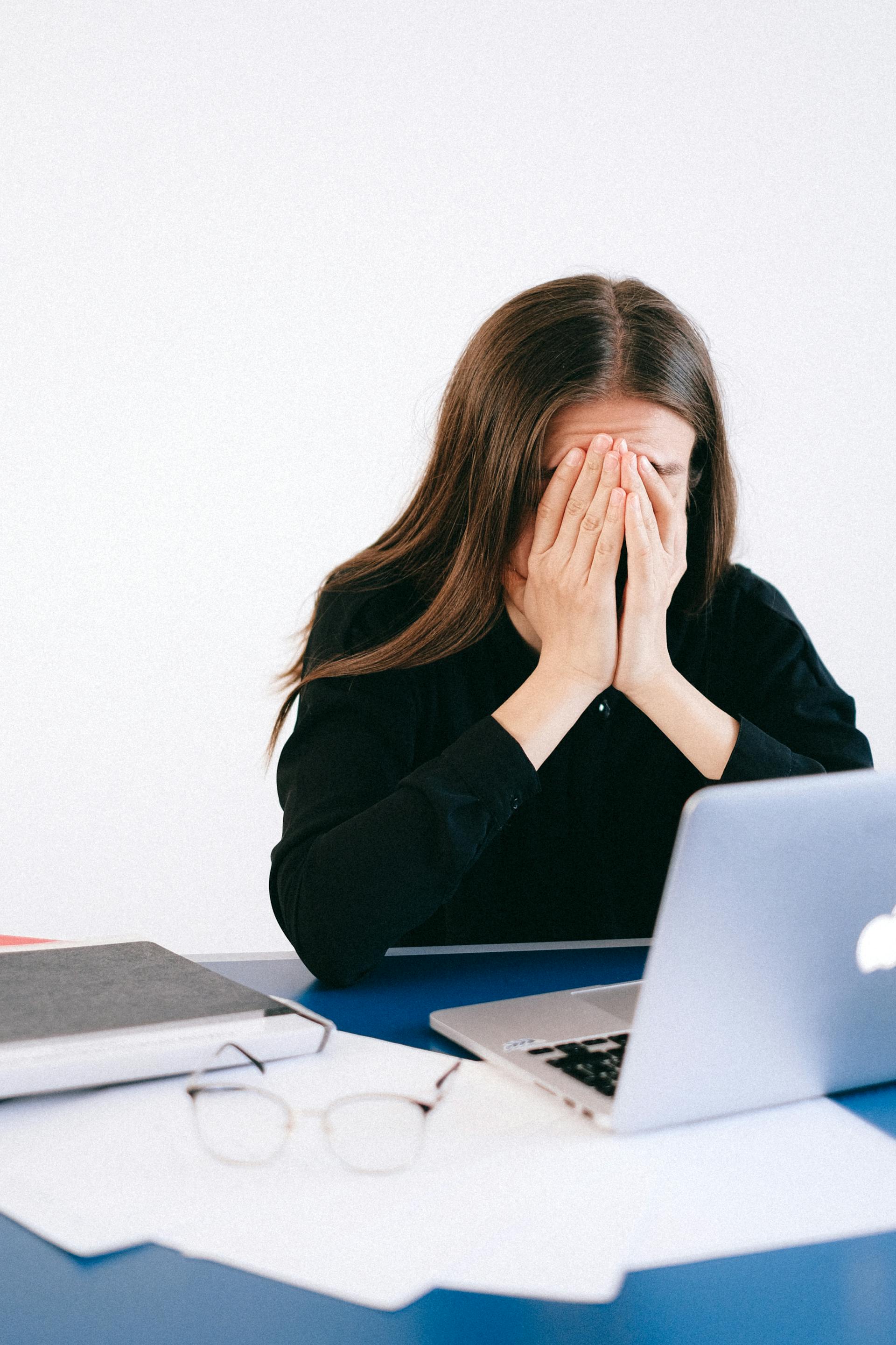 Distressed woman covering her face with her hands | Source: Pexels