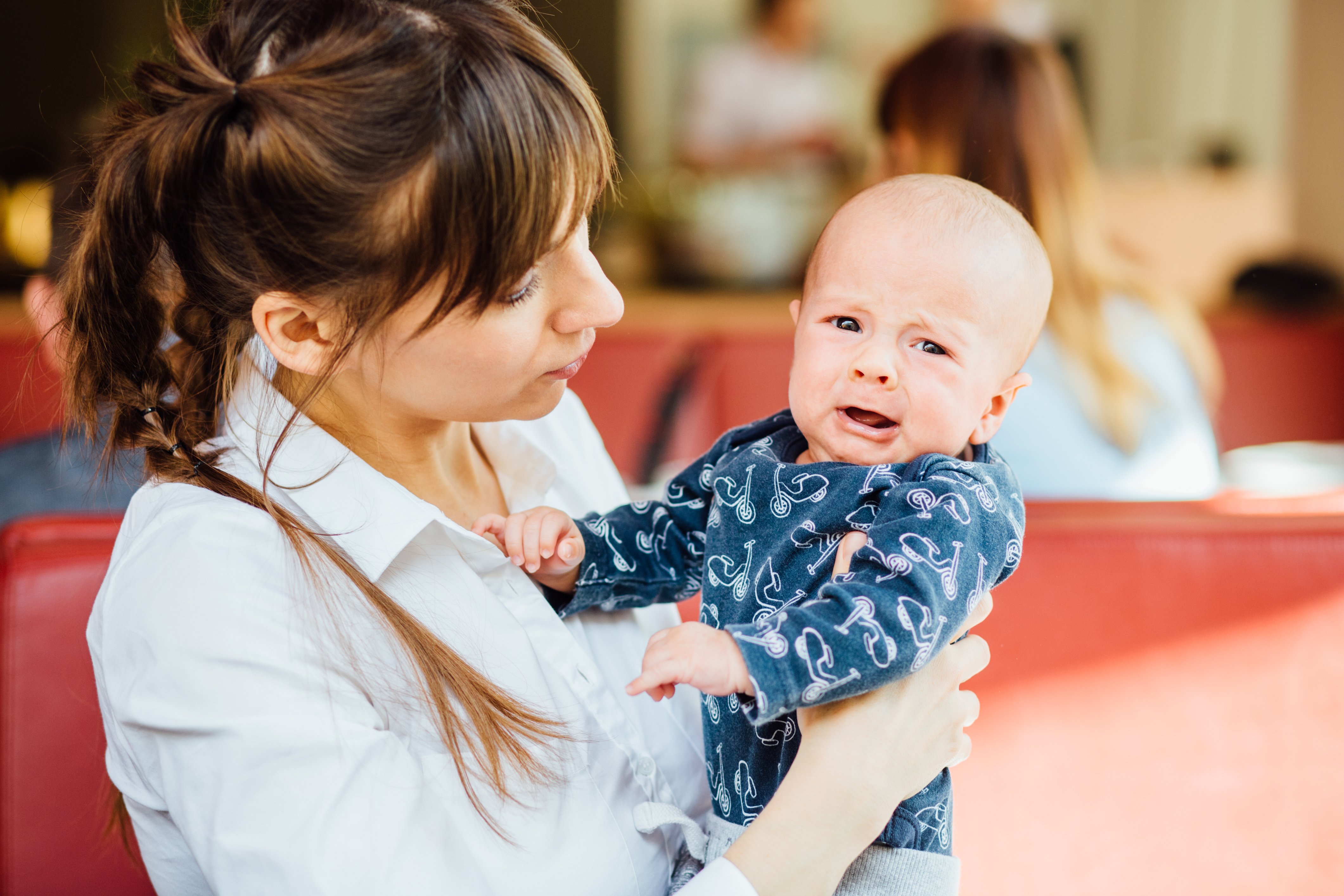 Mother calming down her crying newborn baby boy indoors | Photo: Shutterstock.com