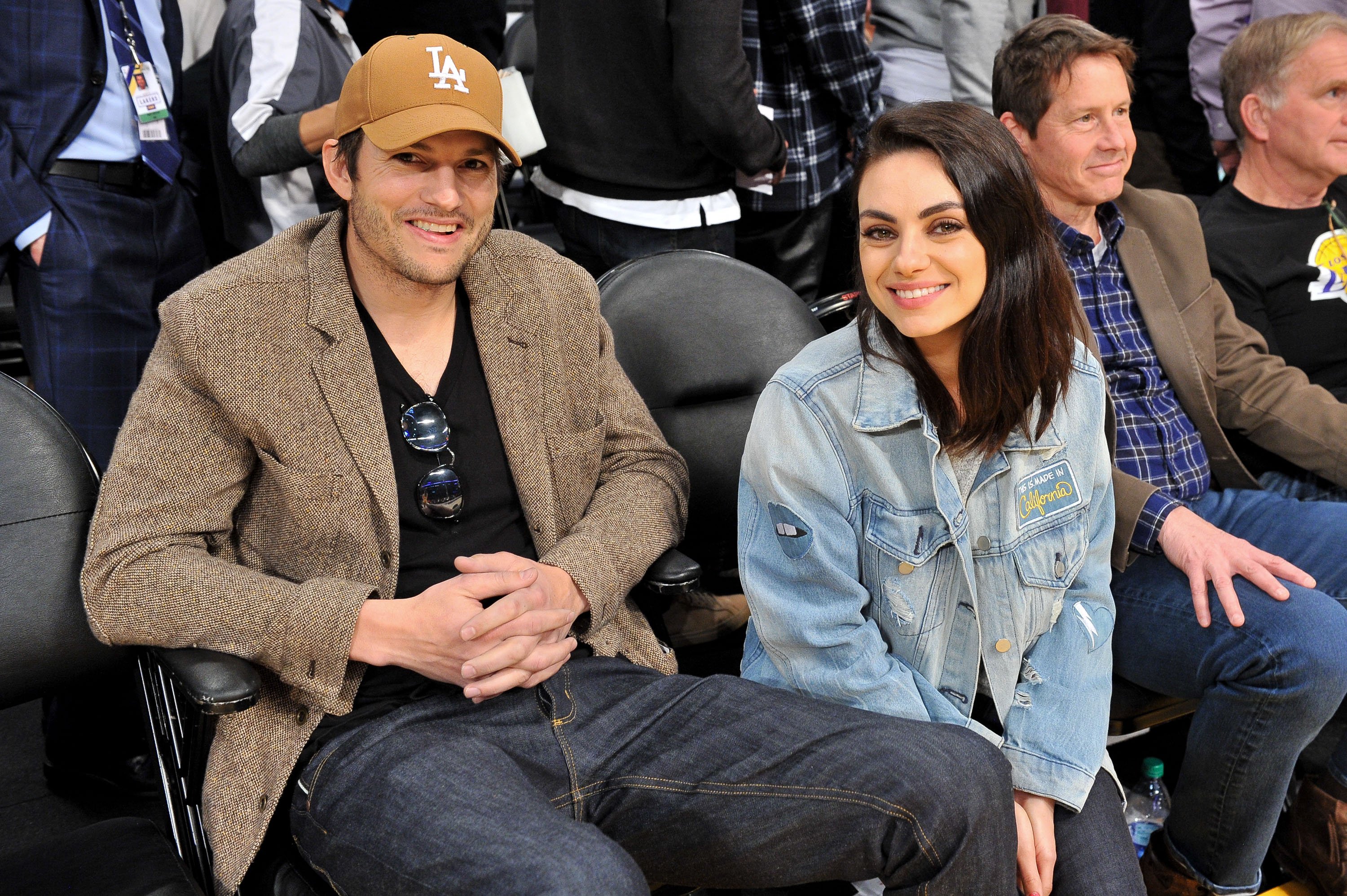 Ashton Kutcher and Mila Kunis smile for the camera at an L.A. Lakers game, January, 2019. | Photo: Getty Images.