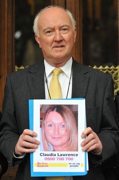 Peter Lawrence, father of missing Claudia Lawrence, holds up poster of his missing loved one | Photo: Getty Images