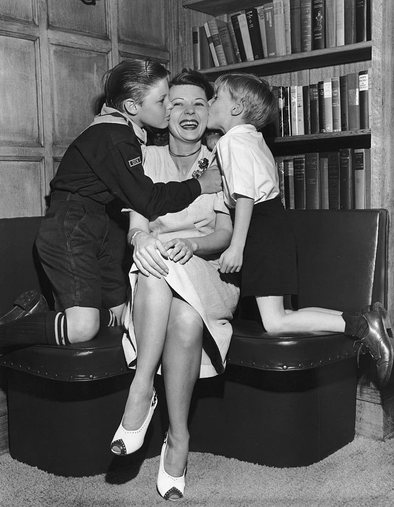 American actress Harriet Nelson receives hugs and kisses from her sons, David Nelson and Ricky Nelson in their home circa 1946 | Photo: Getty Images