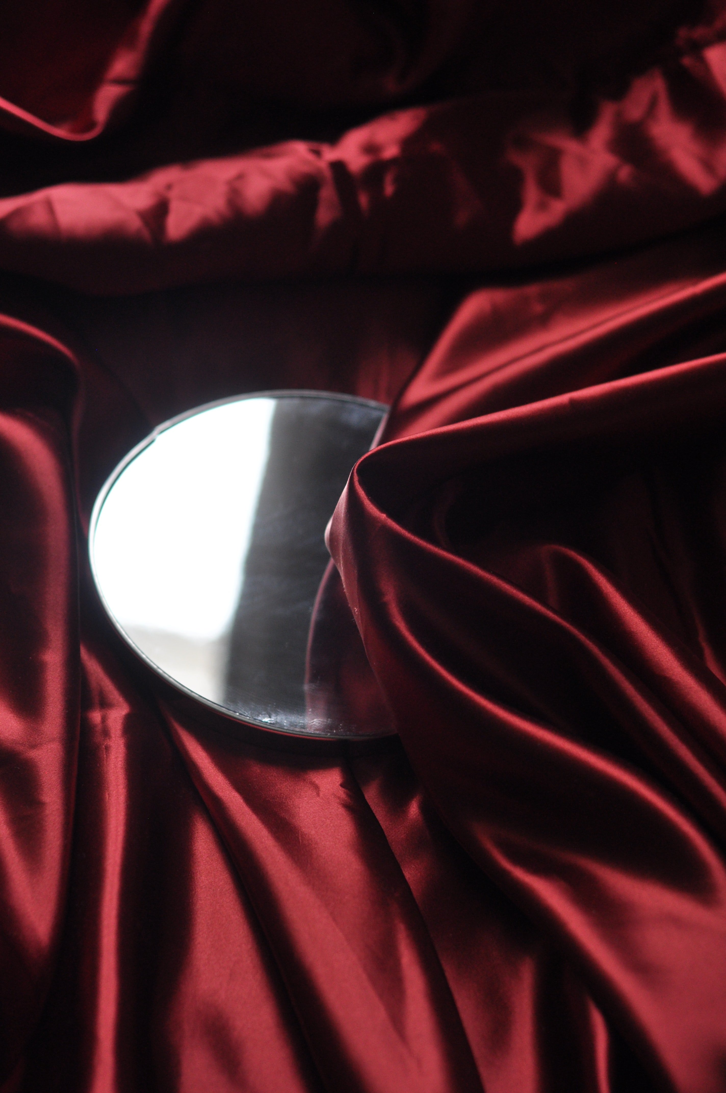 A mirror on top of some red silk | Photo: Unsplash