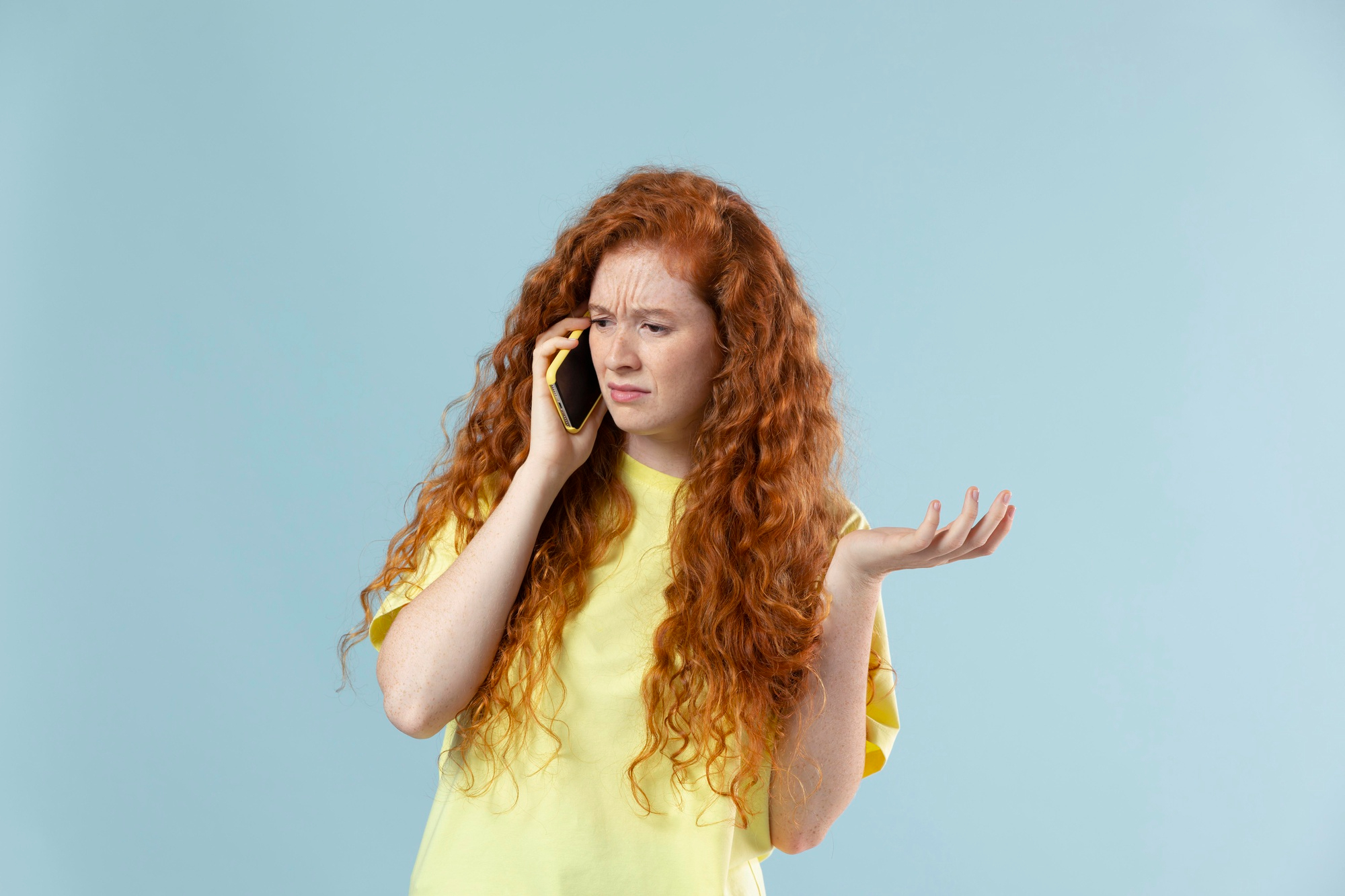 An unhappy woman talking on the phone | Source: Freepik