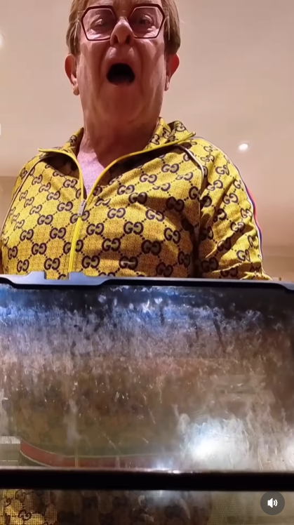 Peering into the oven as the song blares yet again, John lets out a terrified scream — the final straw in his battle against a kitchen that won't stop singing back at him. | Source: Instagram/eltonjohn