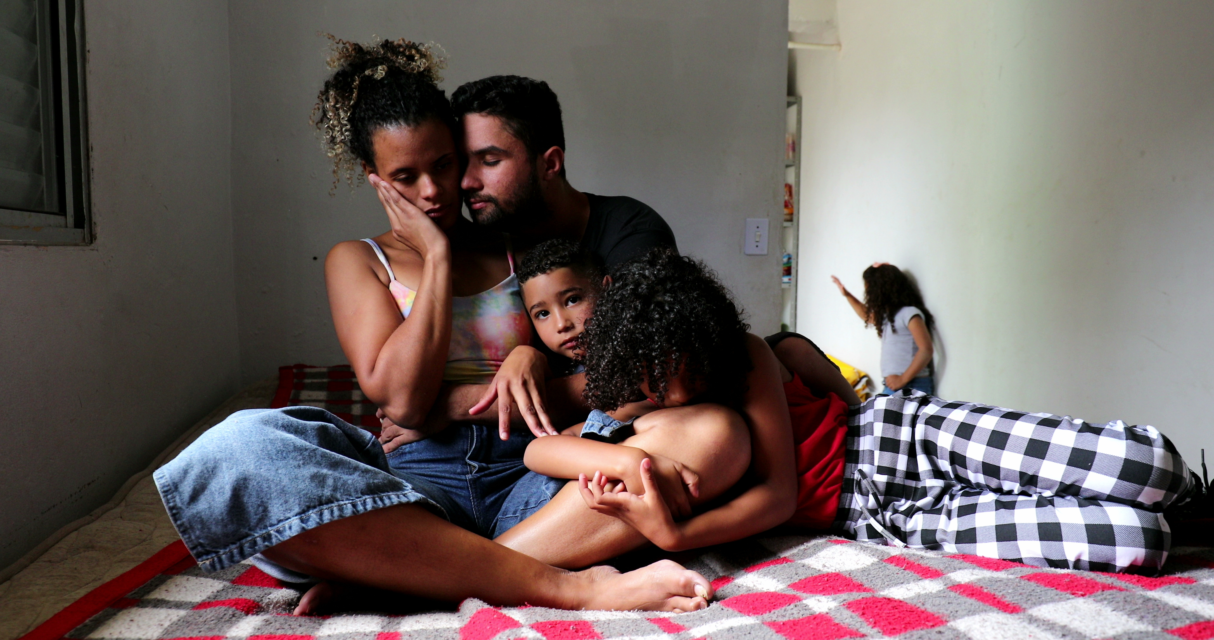 Ein Mann, eine Frau und zwei Kinder beim Kuscheln | Quelle: Shutterstock