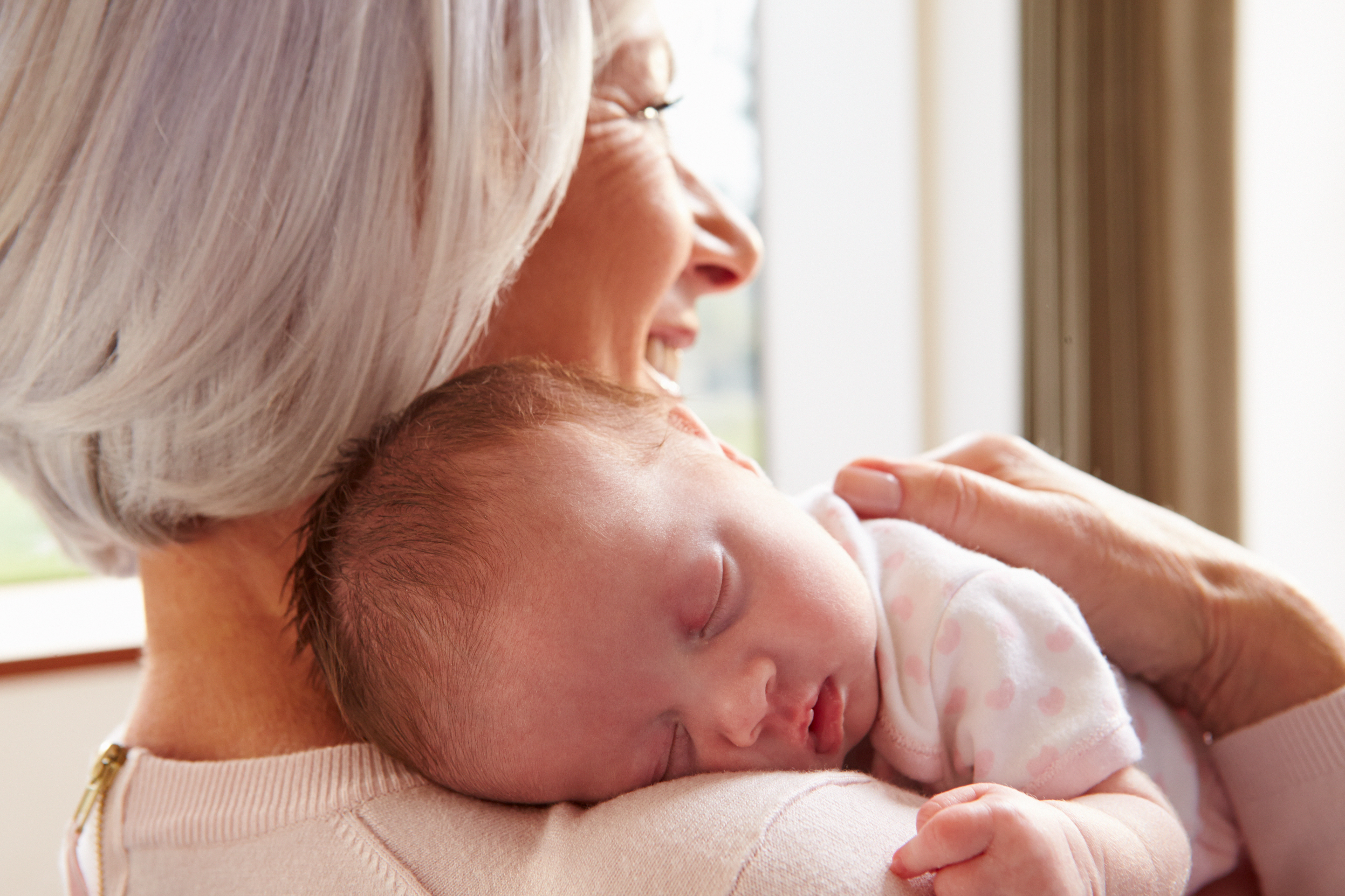 A grandmother holding her newborn grandchild | Source: Shutterstock