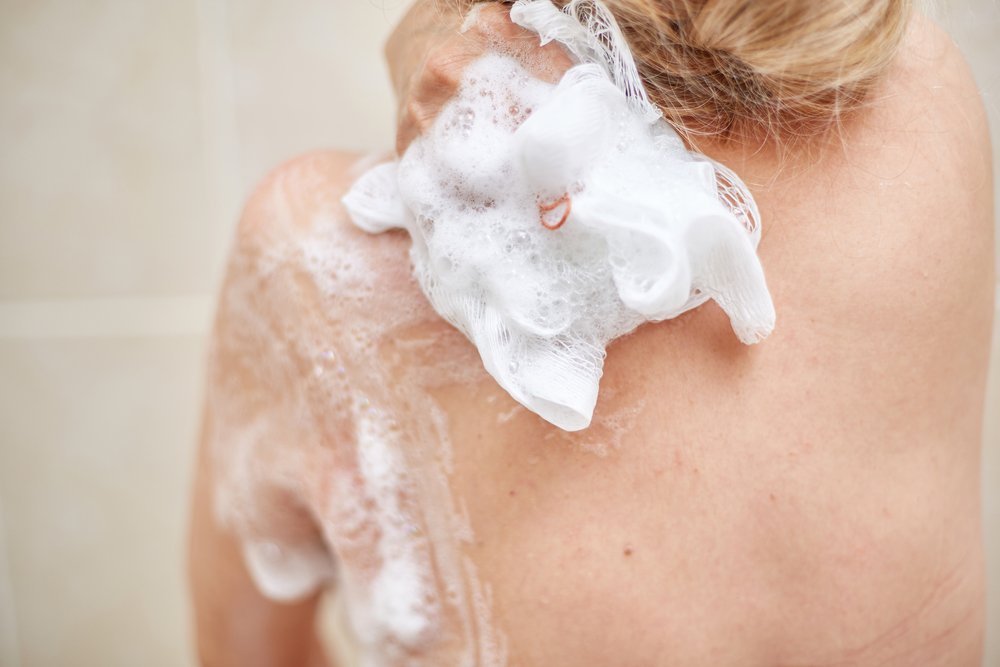 Mujer lavándose el hombro con jabón corporal. | Foto: Shutterstock