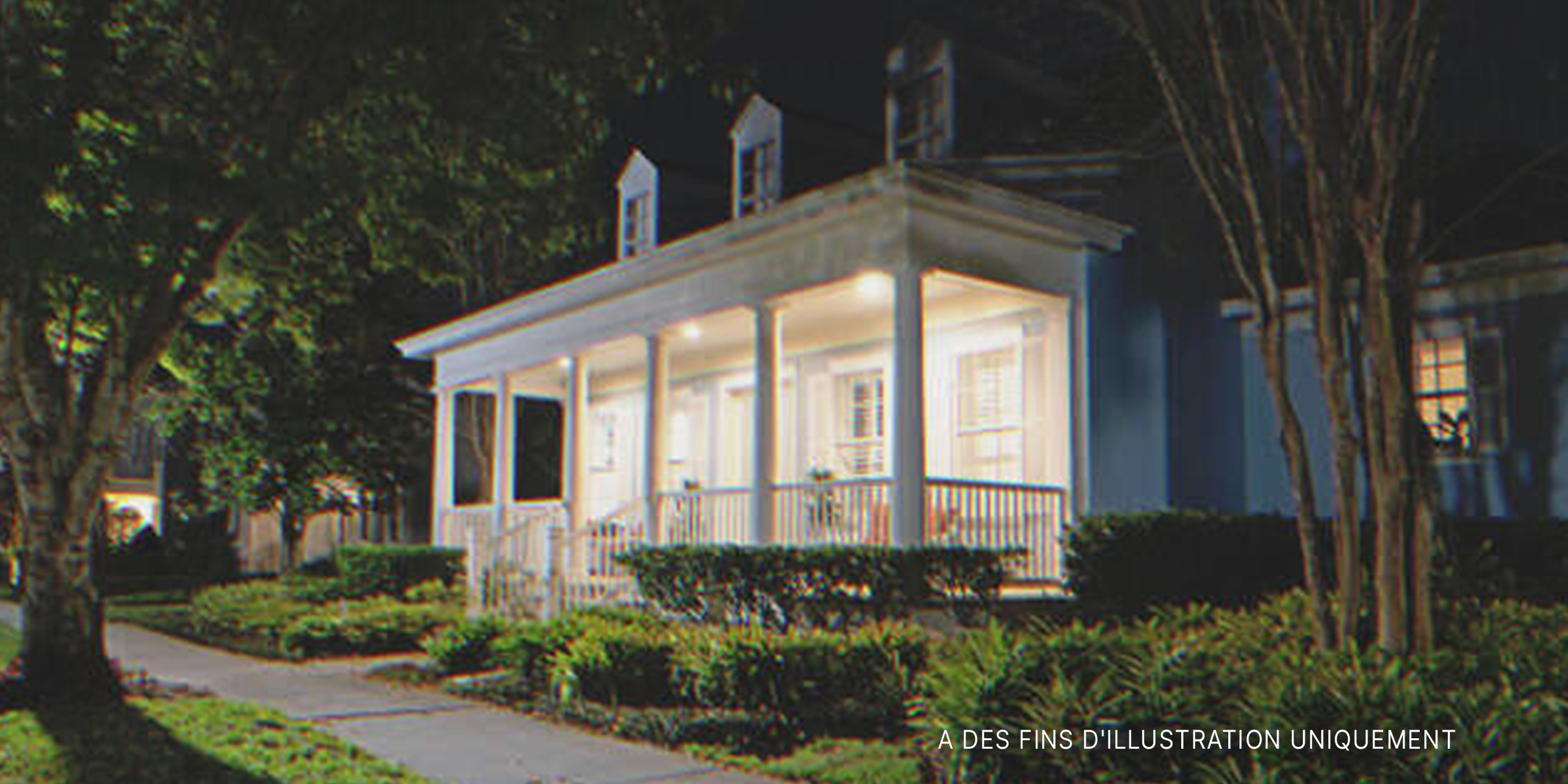 Une maison de banlieue avec des lumières de porche allumées | Source : Shutterstock