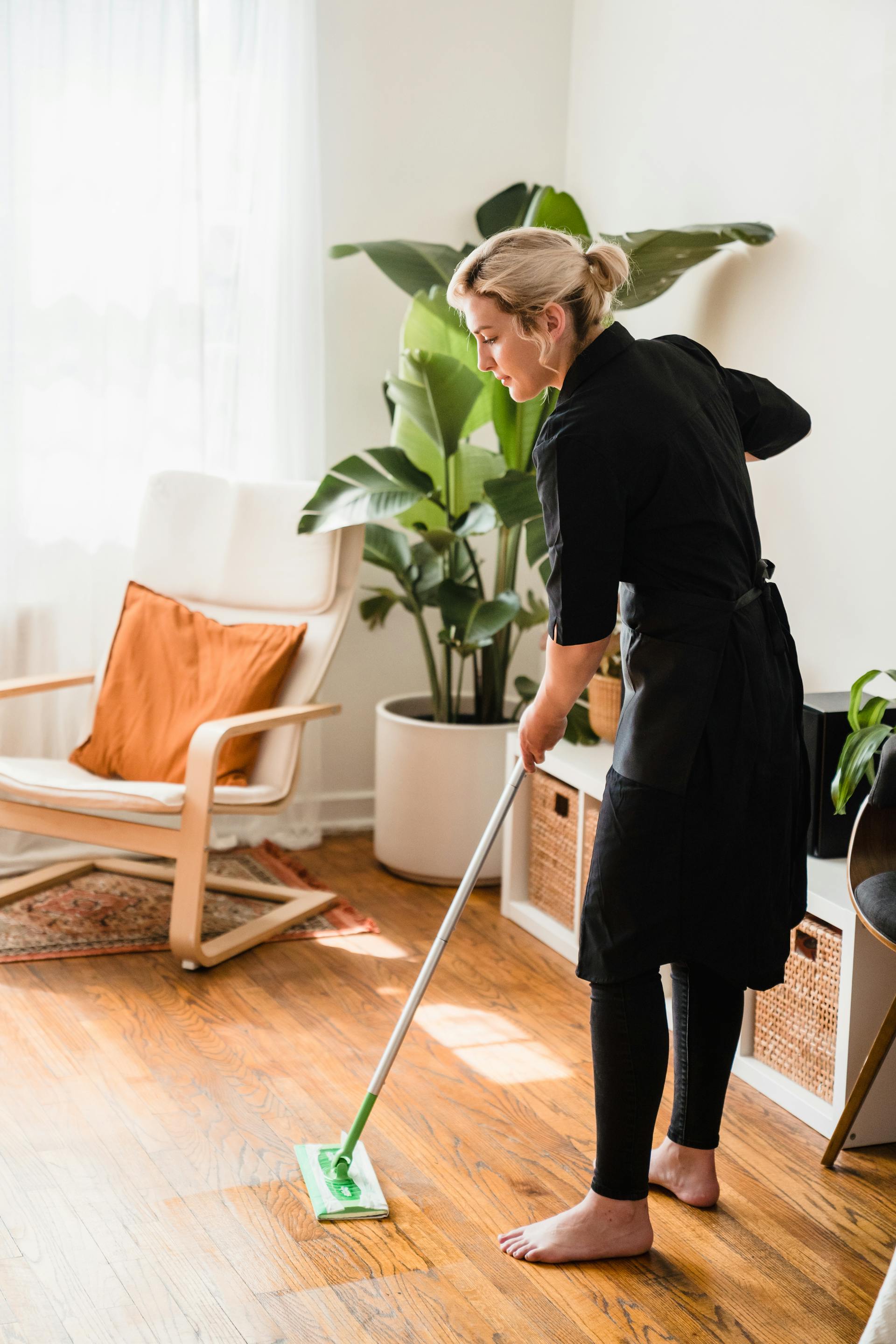 A woman sweeping the floor | Source: Pexels