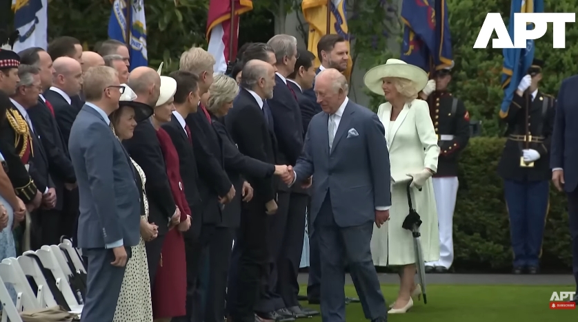 King Charles III is seen greeting members of the U.S. administration during a formal handshake line at the White House in this still taken from a video dated 28 April 2026, as officials stand in formation and Queen Camilla waits just behind, poised to follow in the sequence. | Source: YouTube/APT