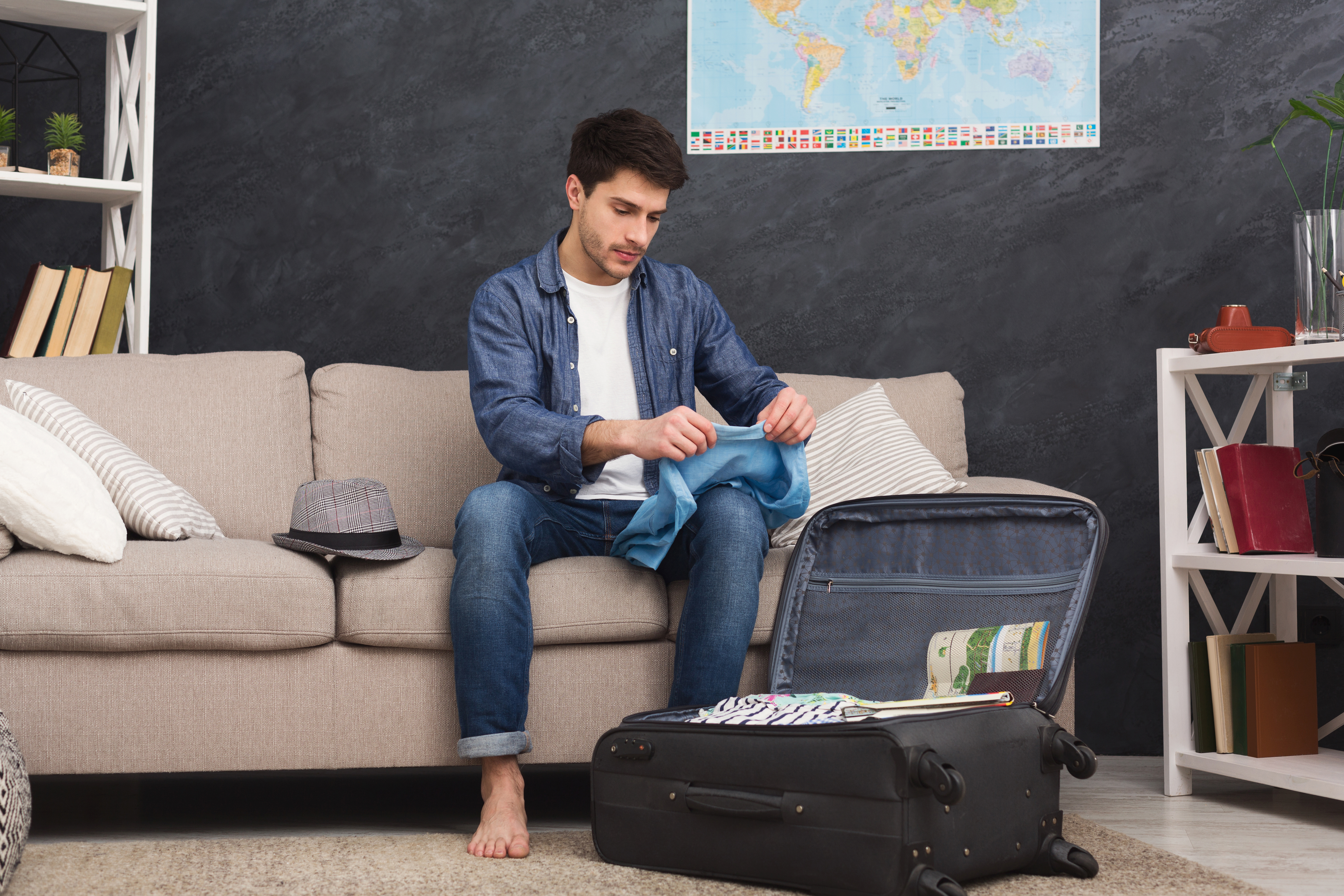 A young man is pictured packing his clothes | Source: Shutterstock