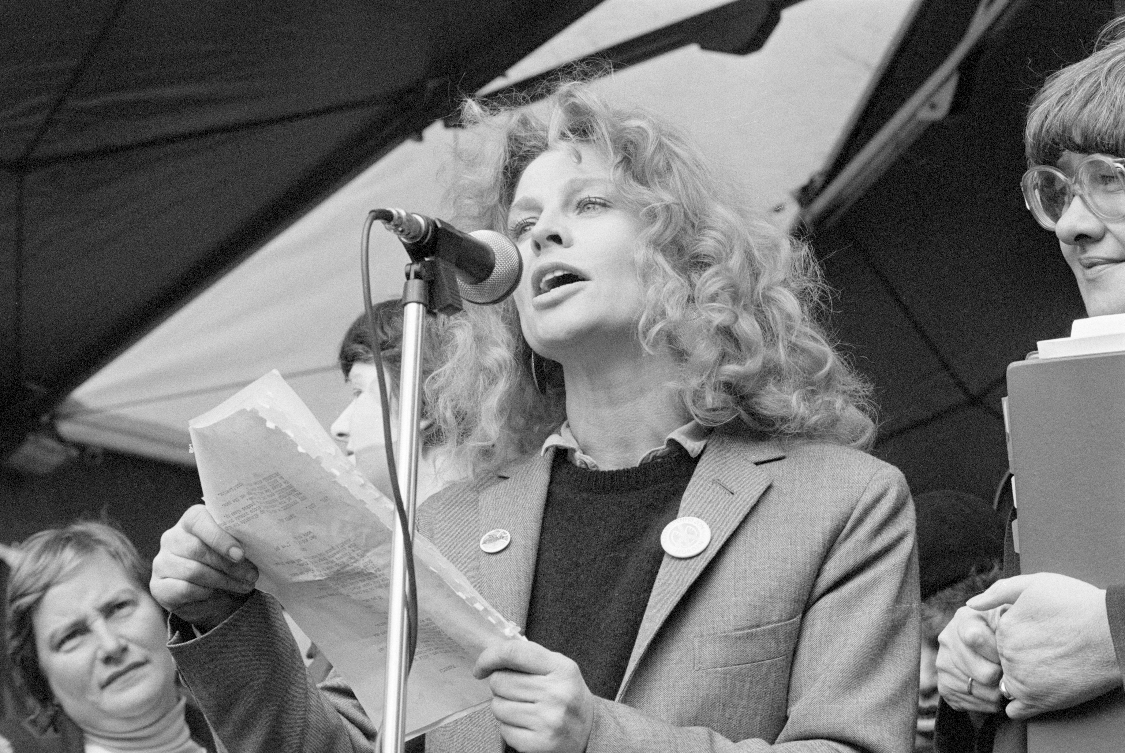 Christie addresses a crowd in Brussels' Place Rogier Square as thousands of women from more than twenty countries gather to protest nuclear weapons and call for peace. Holding her notes at the microphone, Christie lends her voice to the powerful international demonstration — a moment that reflects her long-standing commitment to activism beyond the screen.
