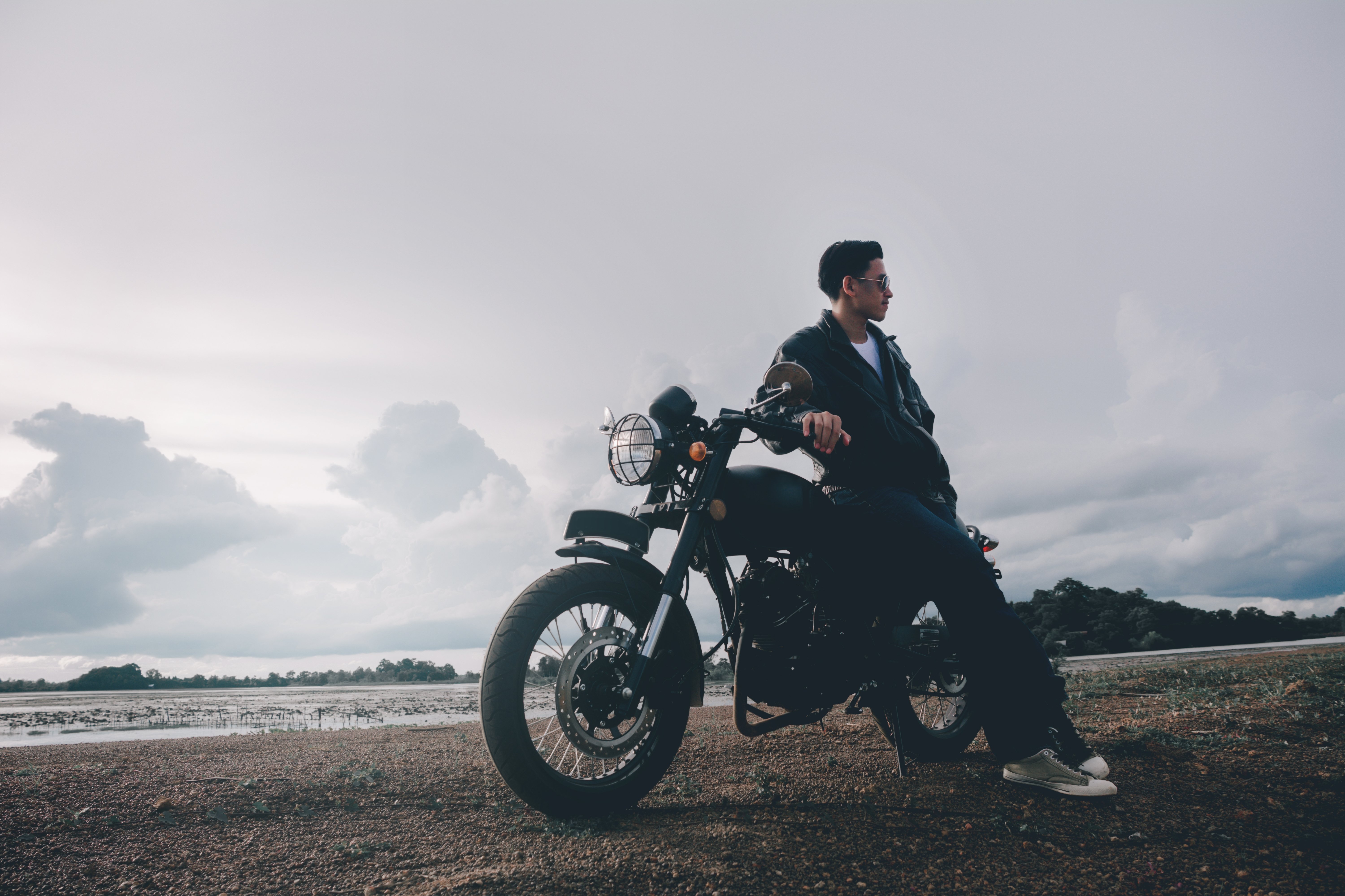 Young man posing with his motorcycle underneath the sunset. |Source: Shutterstock