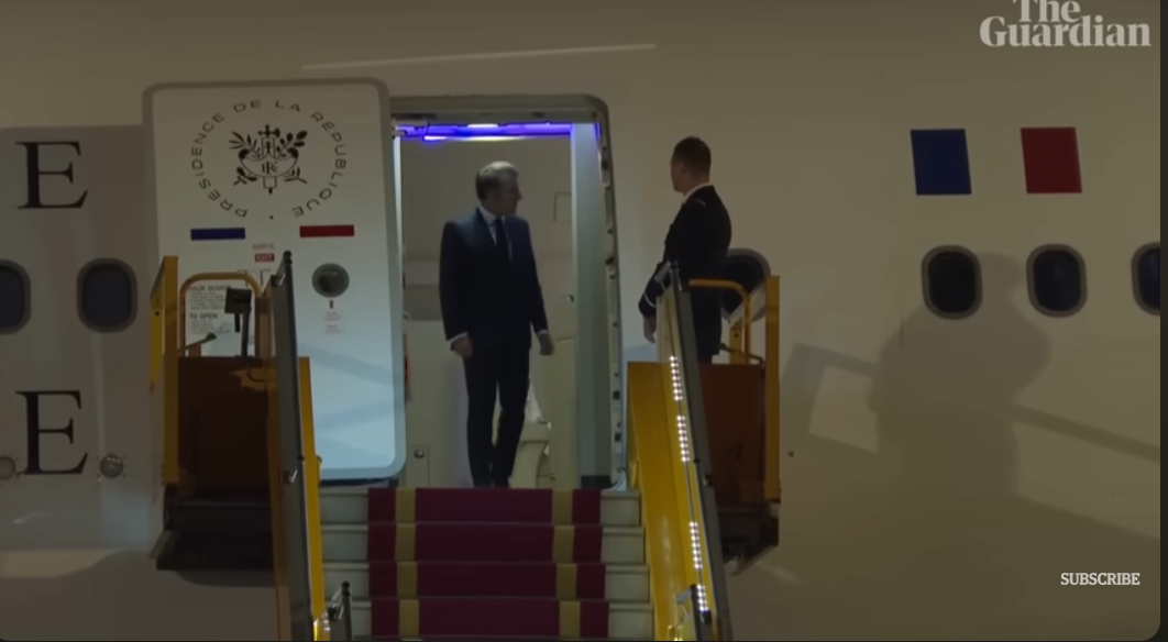 The French president checks his surroundings before descending the stairs | Source: YouTube/The Guardian