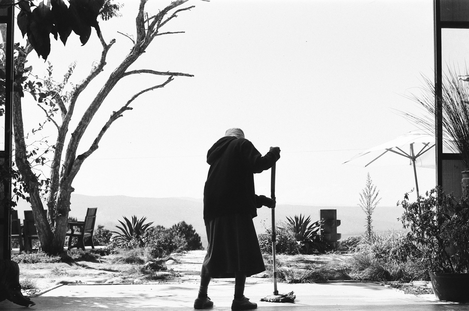 Grayscale shot of an older woman cleaning the floor | Source: Unsplash