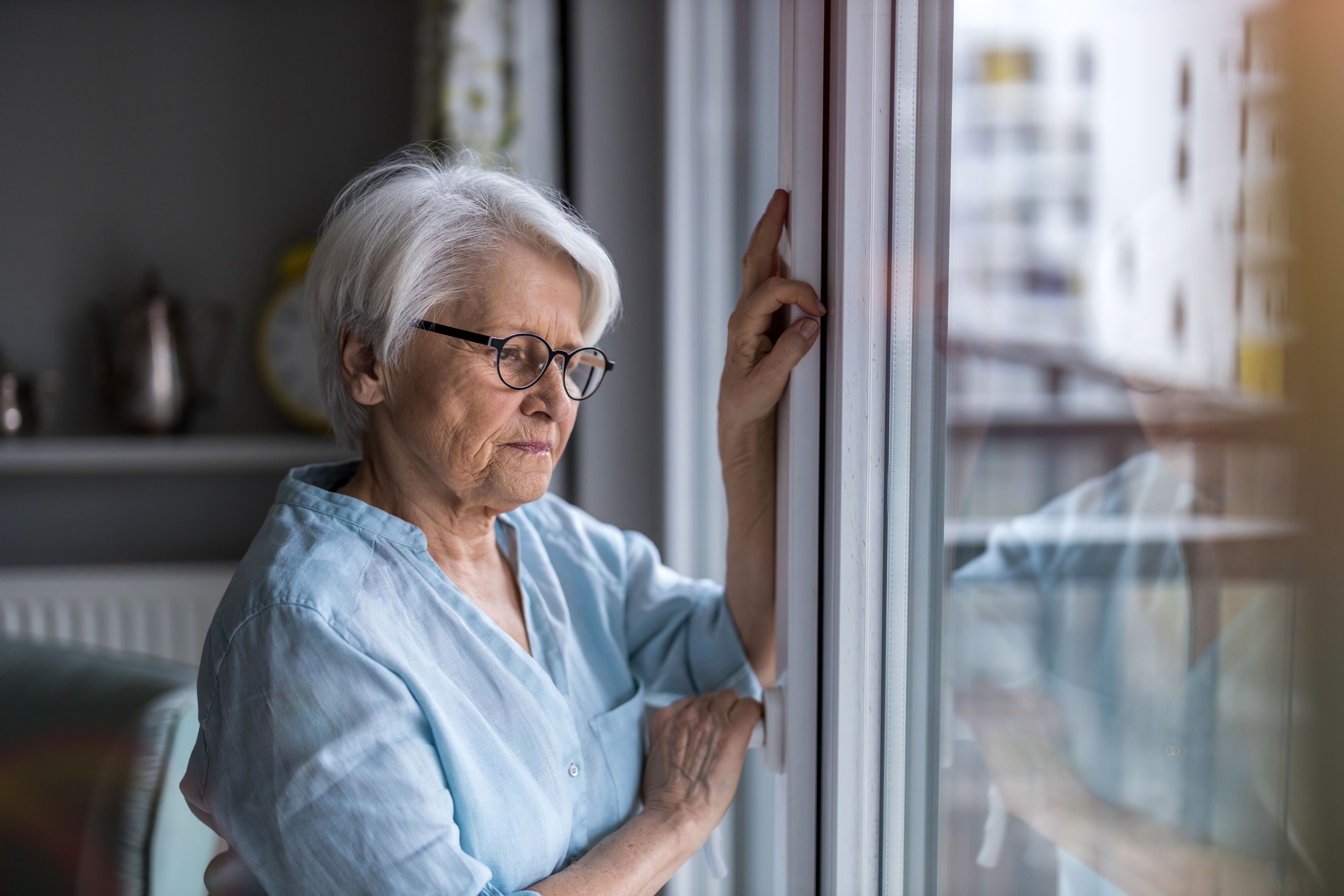 A senior woman looking out a window | Source: Shutterstock