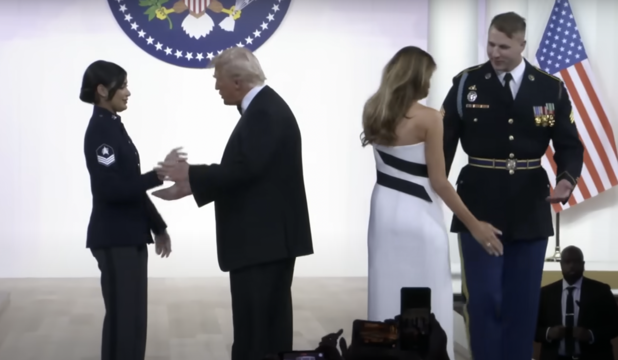 President Donald Trump gets ready to dance with U.S. Space Force Sergeant Tatiana Saldana, while First Lady Melania Trump prepares to dance with U.S. Army Sergeant Henry Waller on January 20, 2025 | Source: YouTube/@InsideEdition