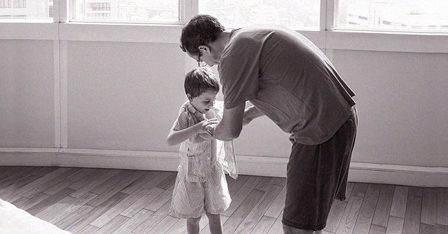 A man dressing a boy | Photo: Freepik