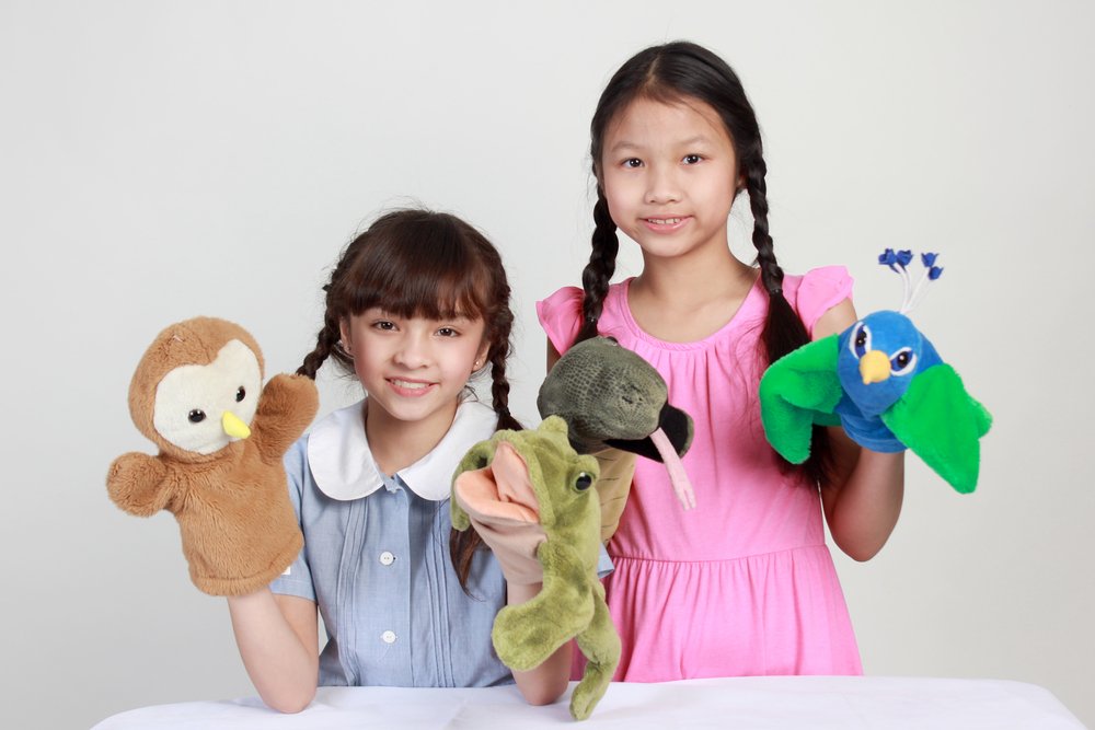 Two girls play puppet show | Photo: Shutterstock