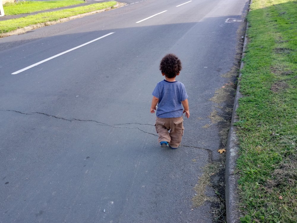 Toddler walking on the road. | Source: Shutterstock