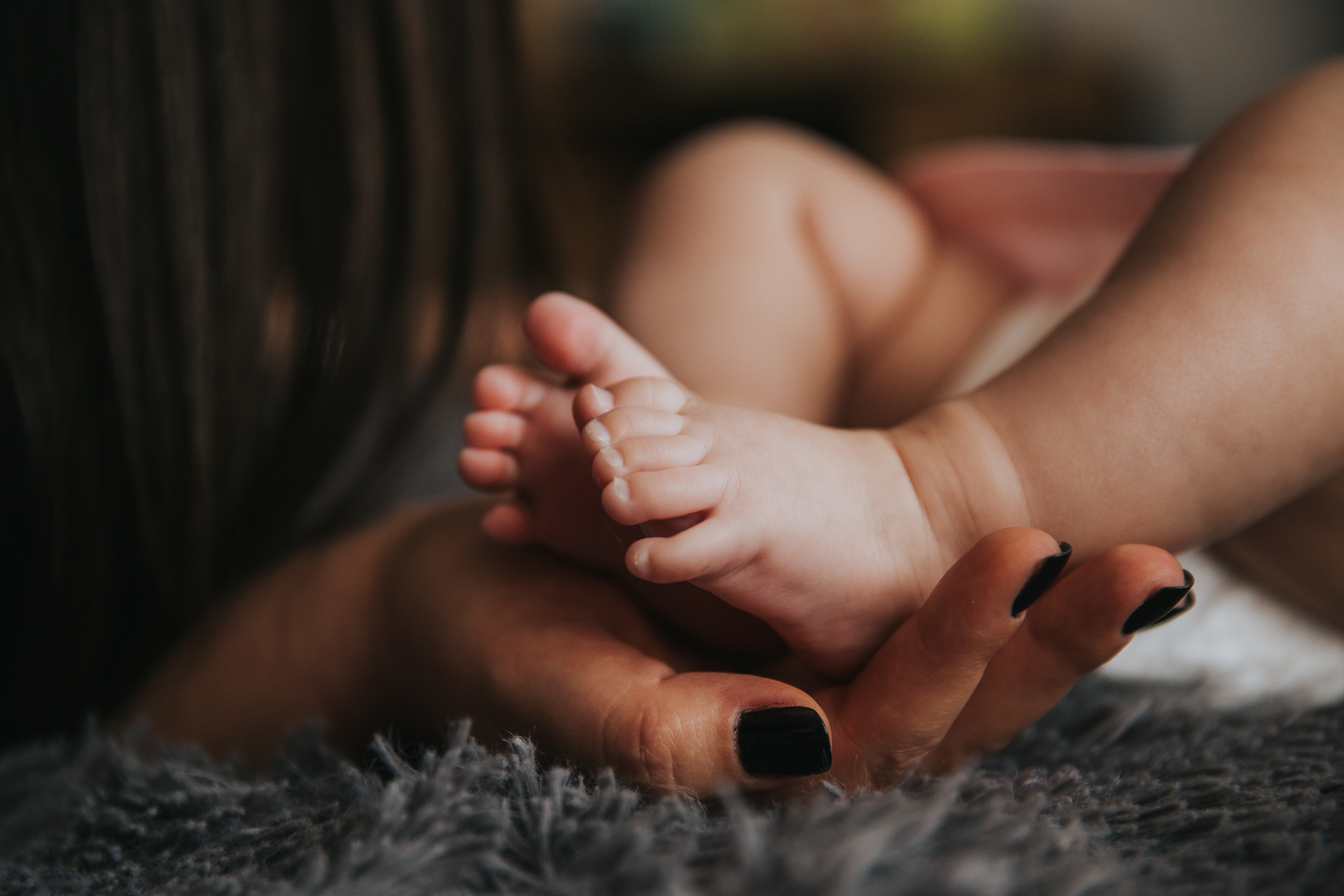 Frau hält Babys Füße | Quelle: Pexels