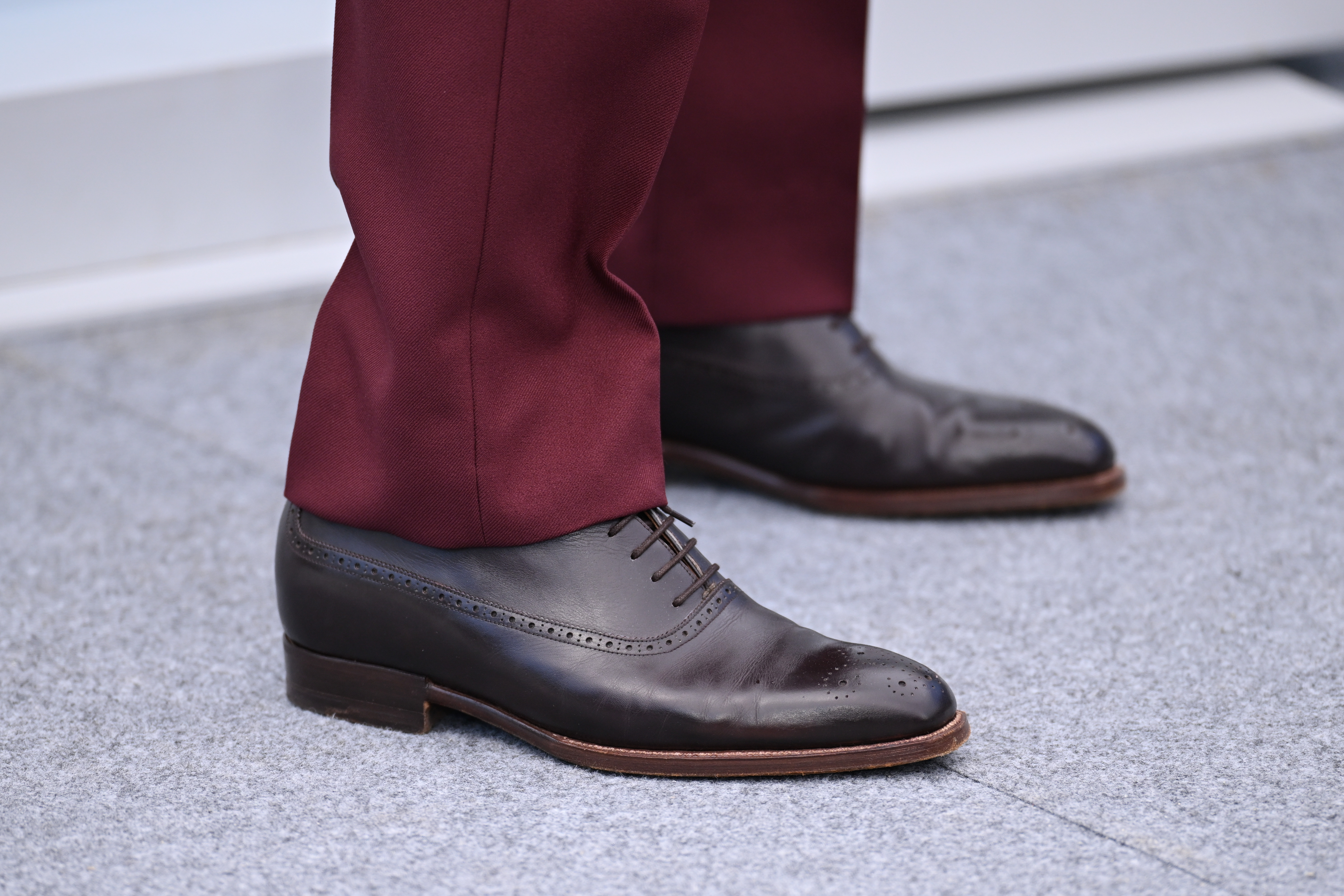 Tom Cruise completes his burgundy look with dark brown leather dress shoes during the photocall for "Mission: Impossible – The Final Reckoning" at the 78th Cannes Film Festival.