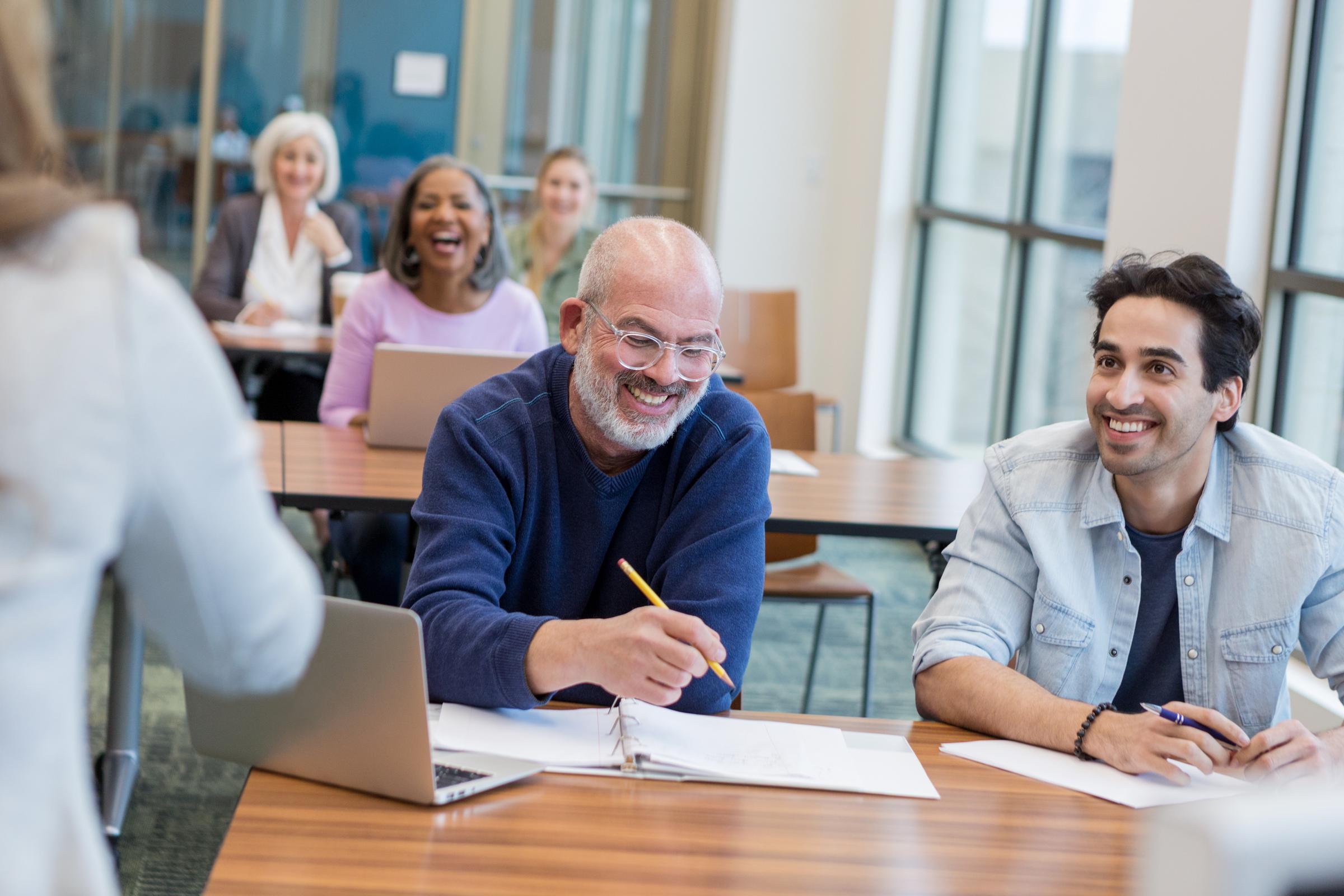 A mixed age groups in a classroom learning new computer skills. | Source: Getty Images