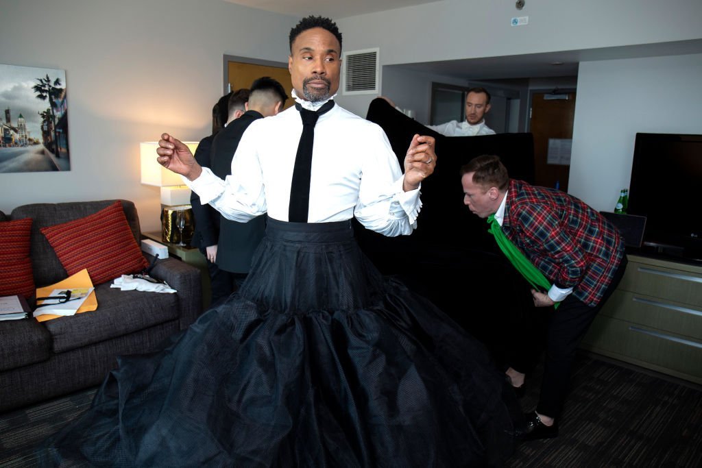 Billy Porter stands in the middle of a hotel room as a team of stylists help him prepare for the 91st Academy Awards at Lowes Hollywood Hotel, on February 24, 2019, in Hollywood, California | Source: Santiago Felipe/Getty Images