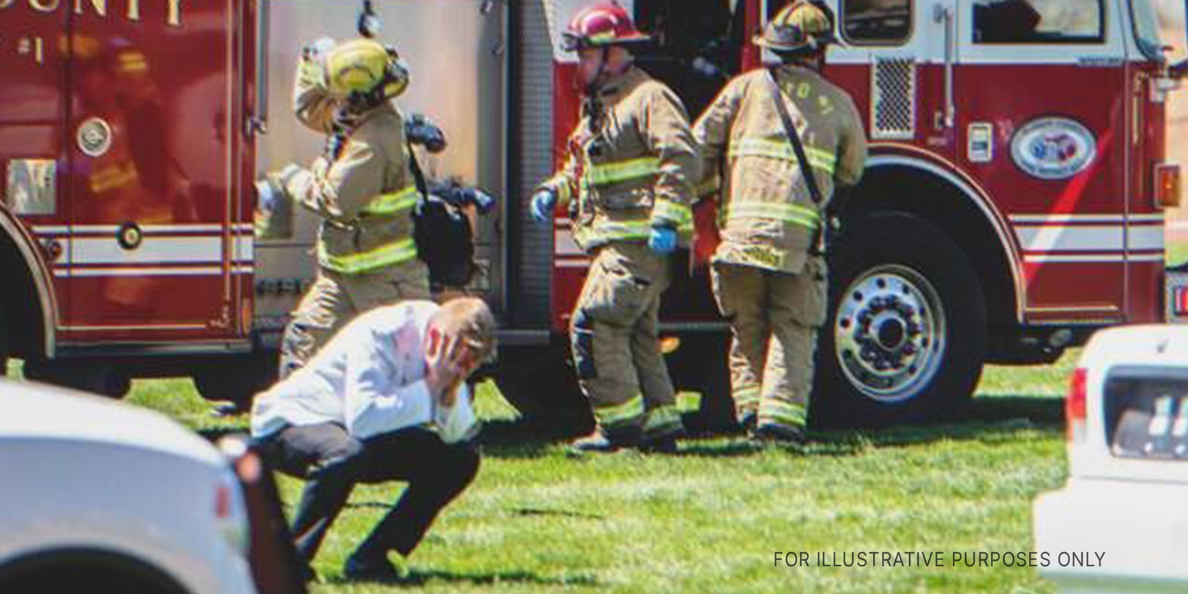 A man holds his head in his hands in front of a fire truck | Source: Shutterstock